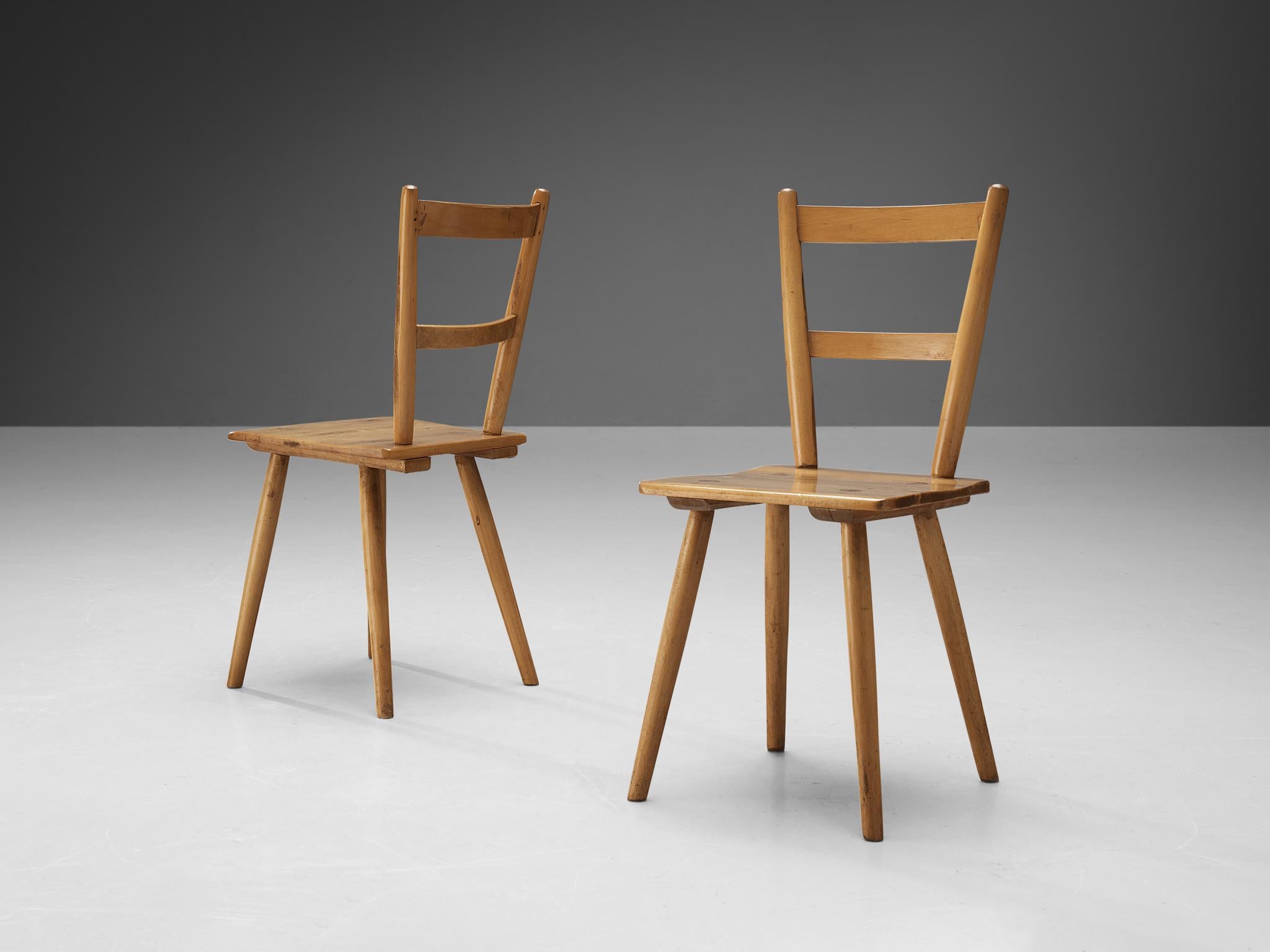 Dining chairs, beech, The Netherlands, 1960s. 

Pair of modest Dutch dining chairs. These modern chairs resemble the style of the designs by the British furniture manufacturer Ercol. These Puritan, simplistic chairs with two horizontal slats contain