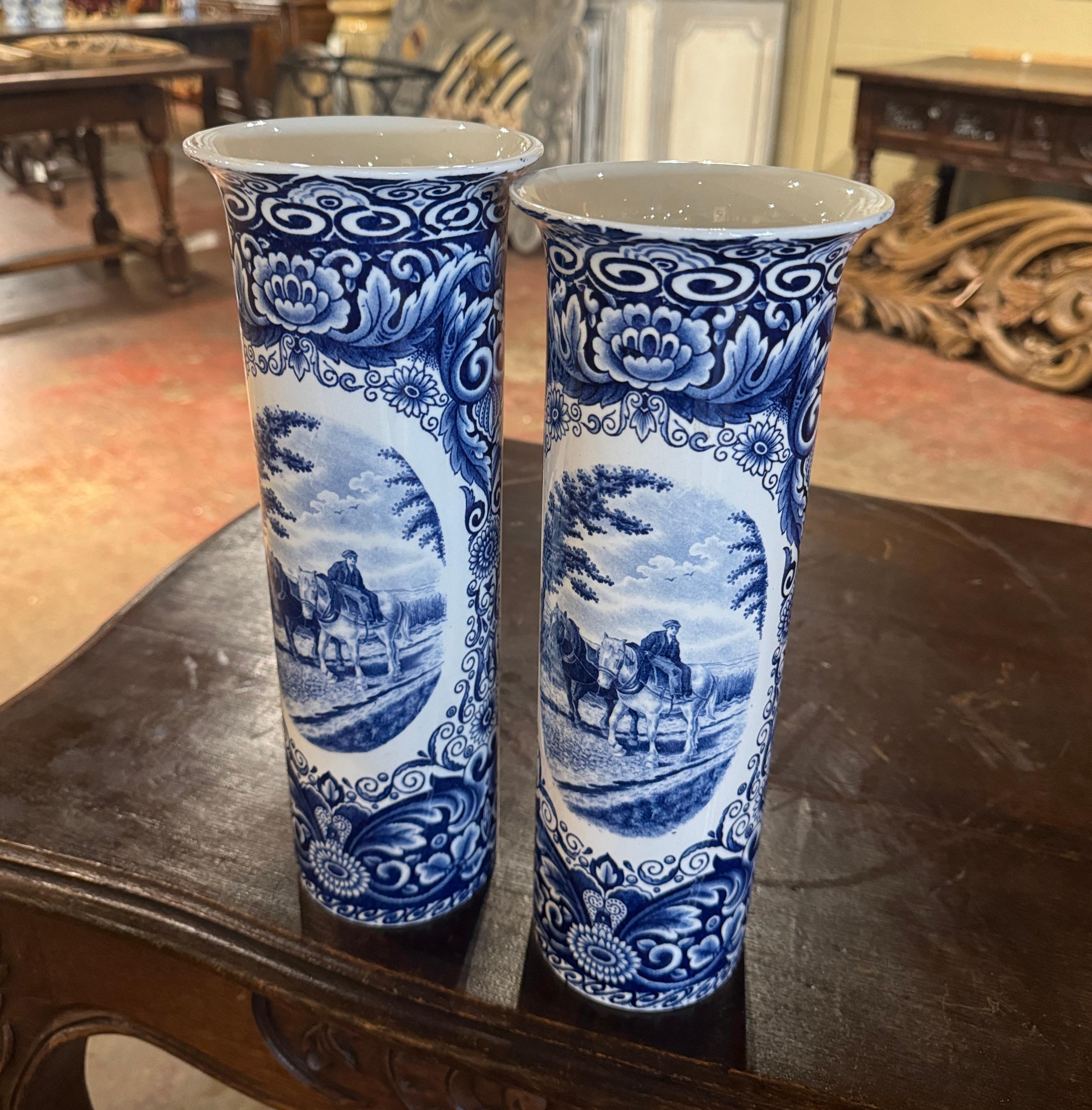 Décorez une étagère ou une table console avec cette élégante paire de vases anciens. Fabriqués en Hollande vers 1940, les vases ronds ont une forme de coquillage avec un large rebord au sommet et sont peints à la main dans la palette bleue et