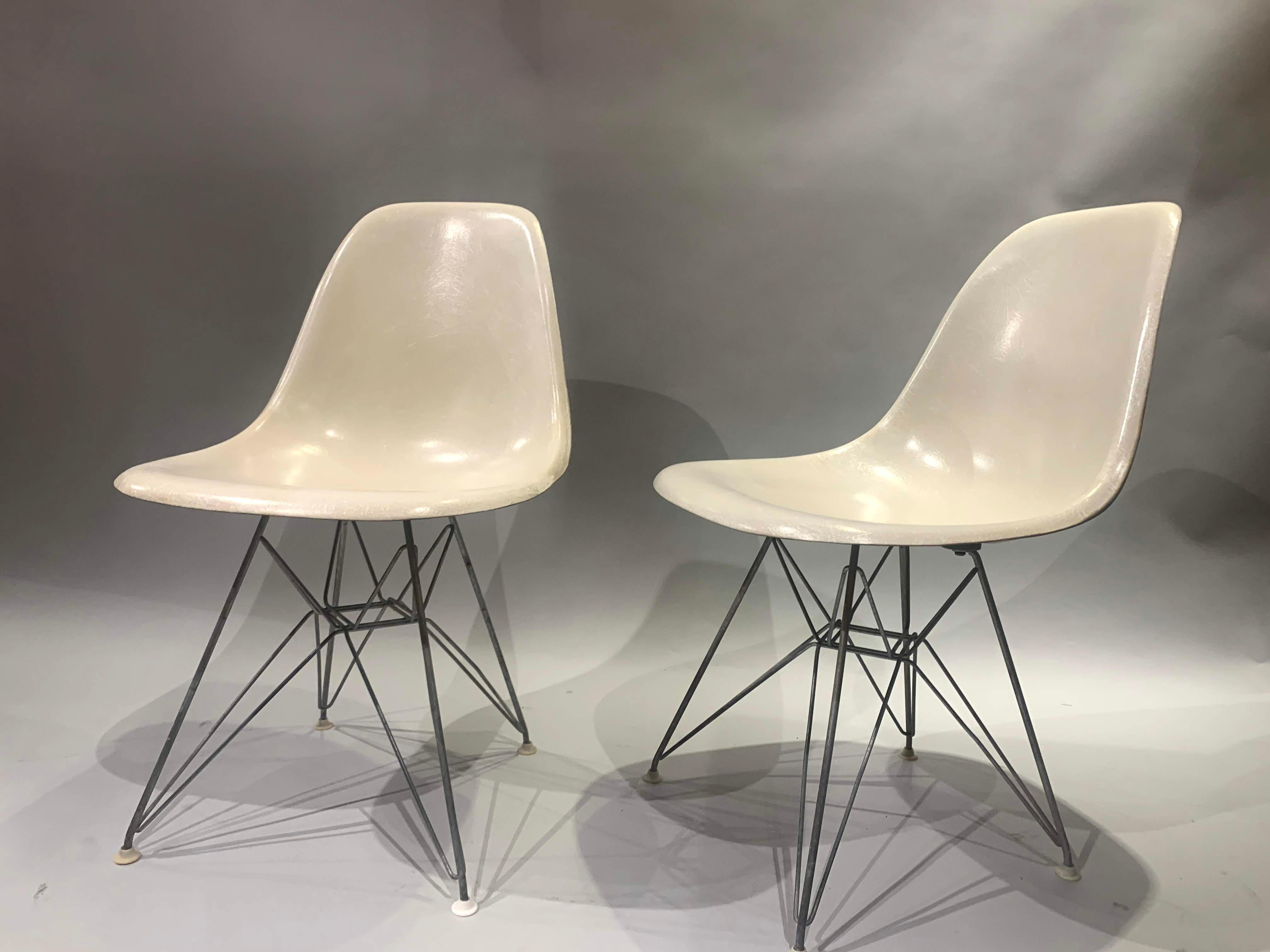 A fine pair of midcentury Charles and Ray Eames designed fiberglass side shell chairs for Herman Miller, with ebonized Eiffel Tower form wire bases in fine overall condition, with minimal imperfections and light expected wear. Dimensions: Each