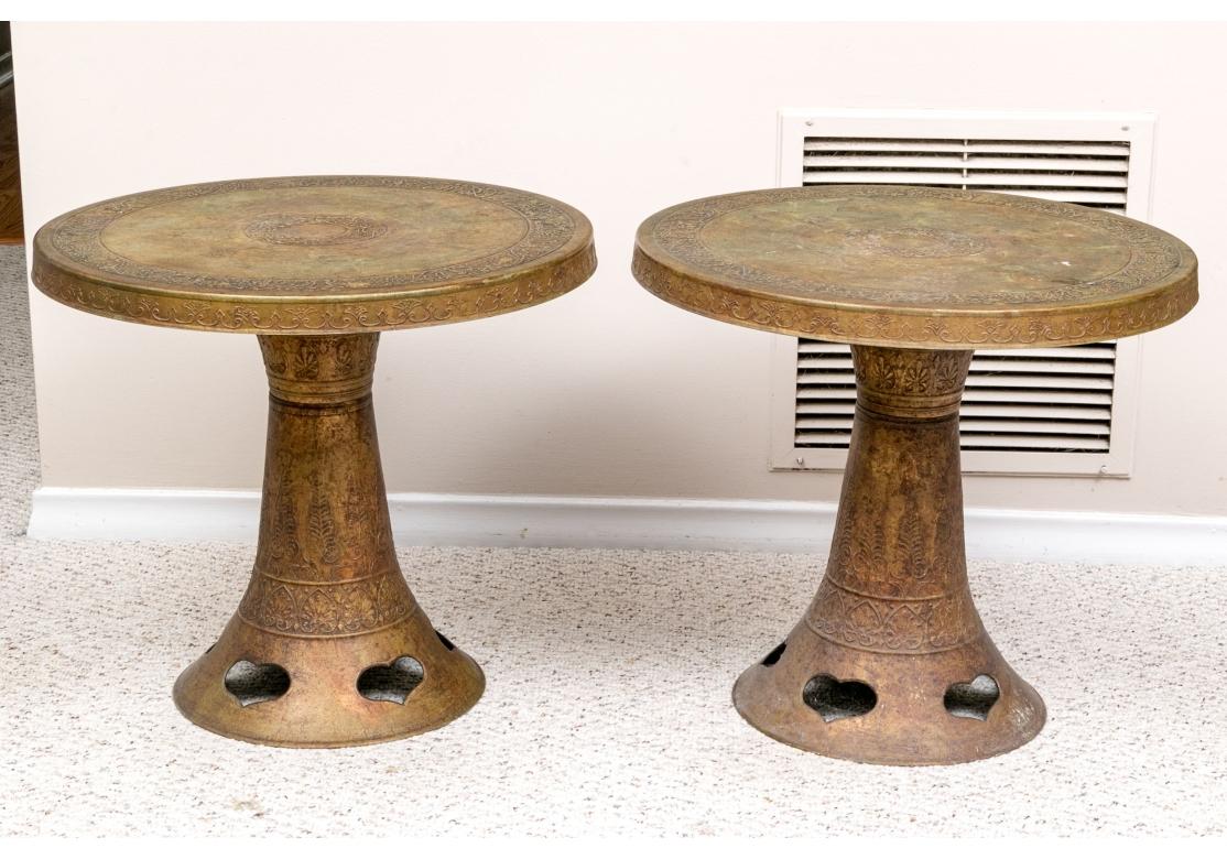Round tops with raised foliate center and outer bands. Raised on trumpet shaped supports with heart shaped cut outs and decorated with low relief bands with leaves and palmettes. 

Dimensions:

22