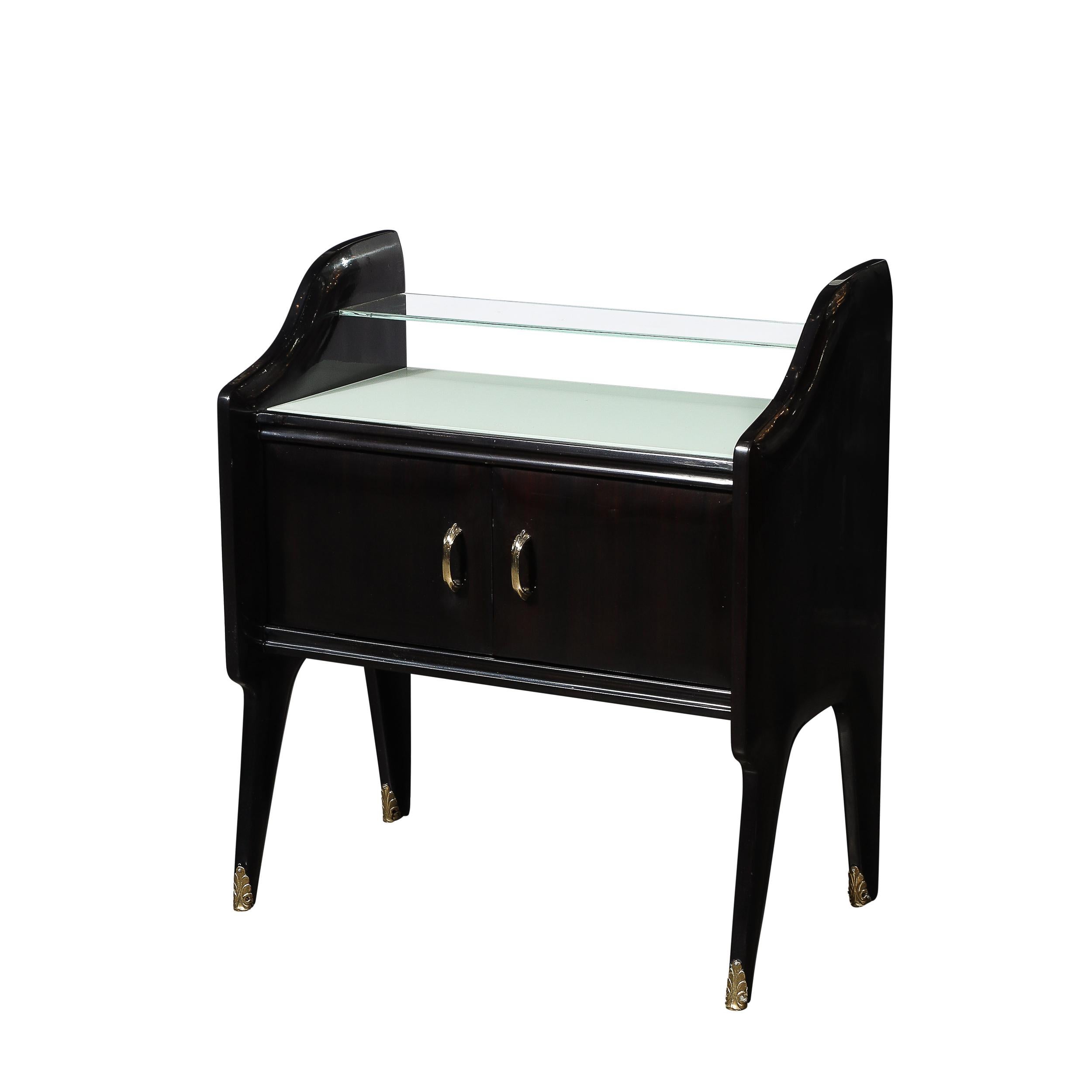 This elegantly reserved Pair of Mid-Century Modernist Sculptural Nightstands in Ebonized Walnut W/Brass Pulls and Sabots are by the esteemed designer Ico Parisi and originate from Italy Circa 1950. Features a two tier top surface containing a narrow