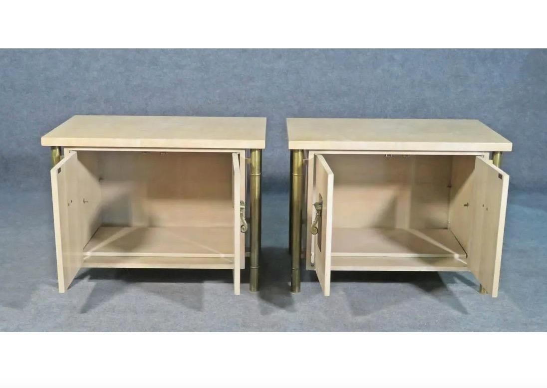 This pair of vintage end tables by Mastercraft combines brass, faux bamboo, and a beautiful cream-colored surface with unusual details like decorative handles for a unique Mid-Century Modern design. Please confirm item location with seller (NY/NJ).