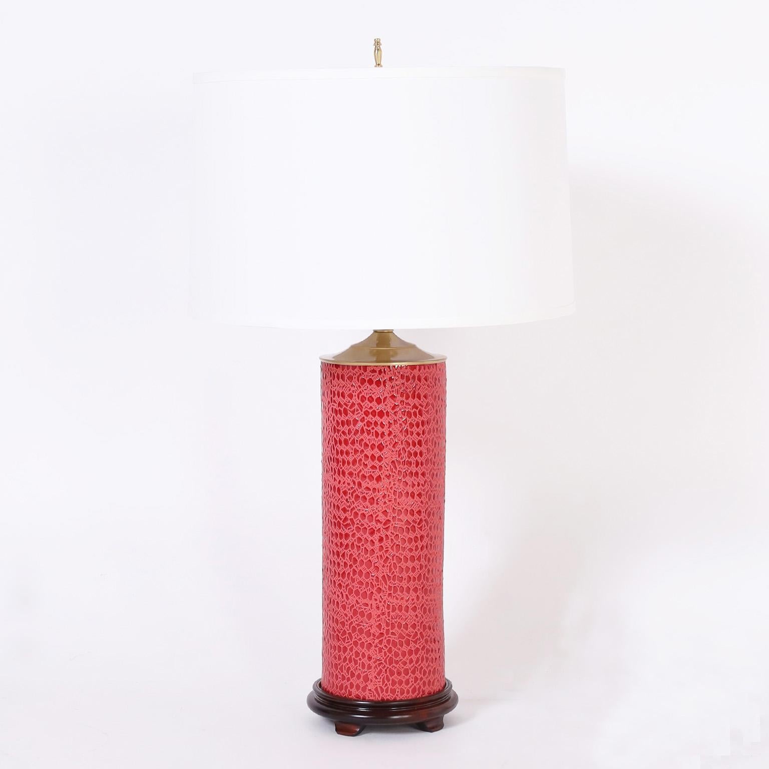 Striking pair of vintage table lamps crafted in ceramic or porcelain with a faux red leather alligator finish presented on a wood base.