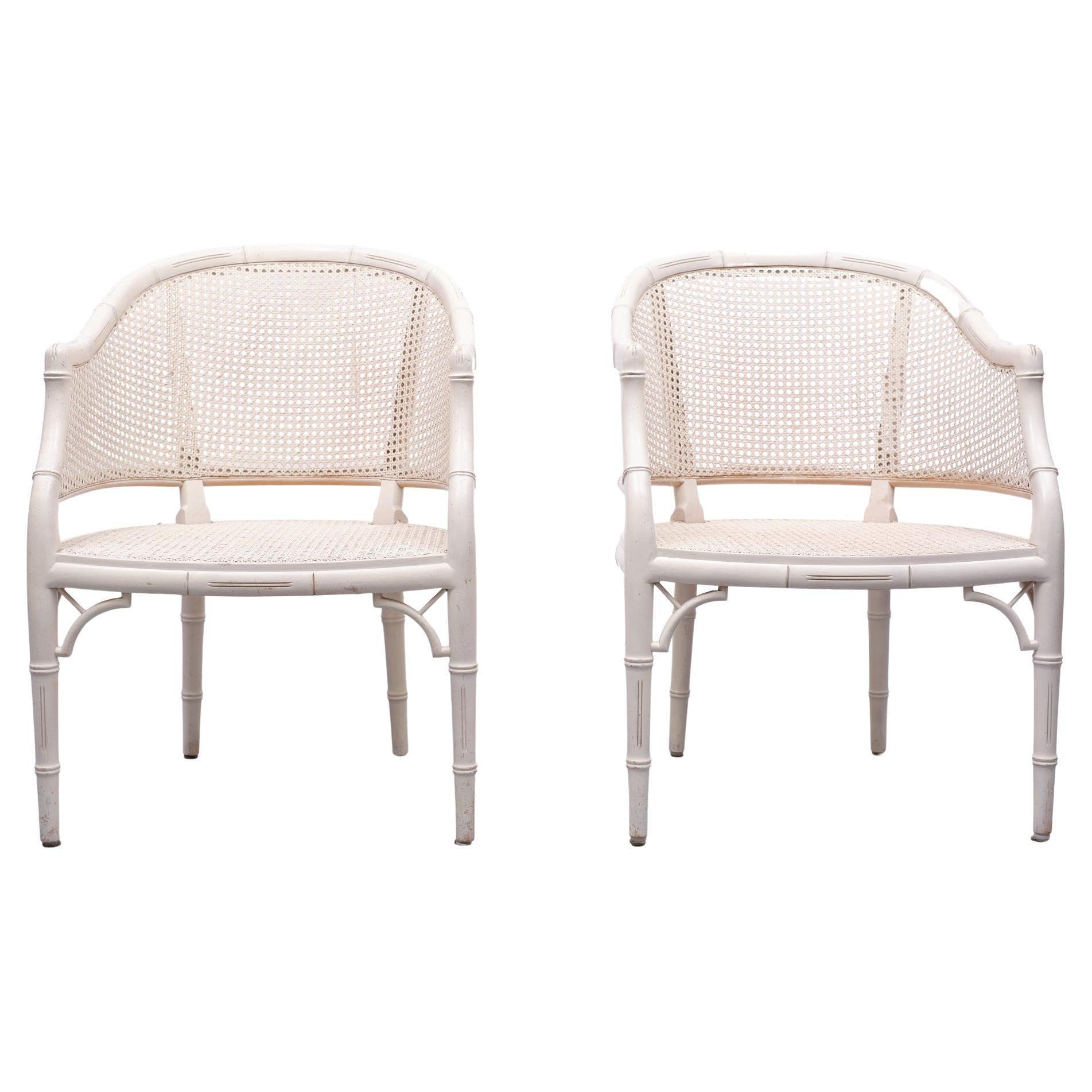 Very nice pair of Mid-Century Modern barrel chairs. Featuring a handcrafted faux-bamboo wooden frame with a caned back and sides. Made in the Hollywood Regency style with a loose seat cushion. In a off white color.
