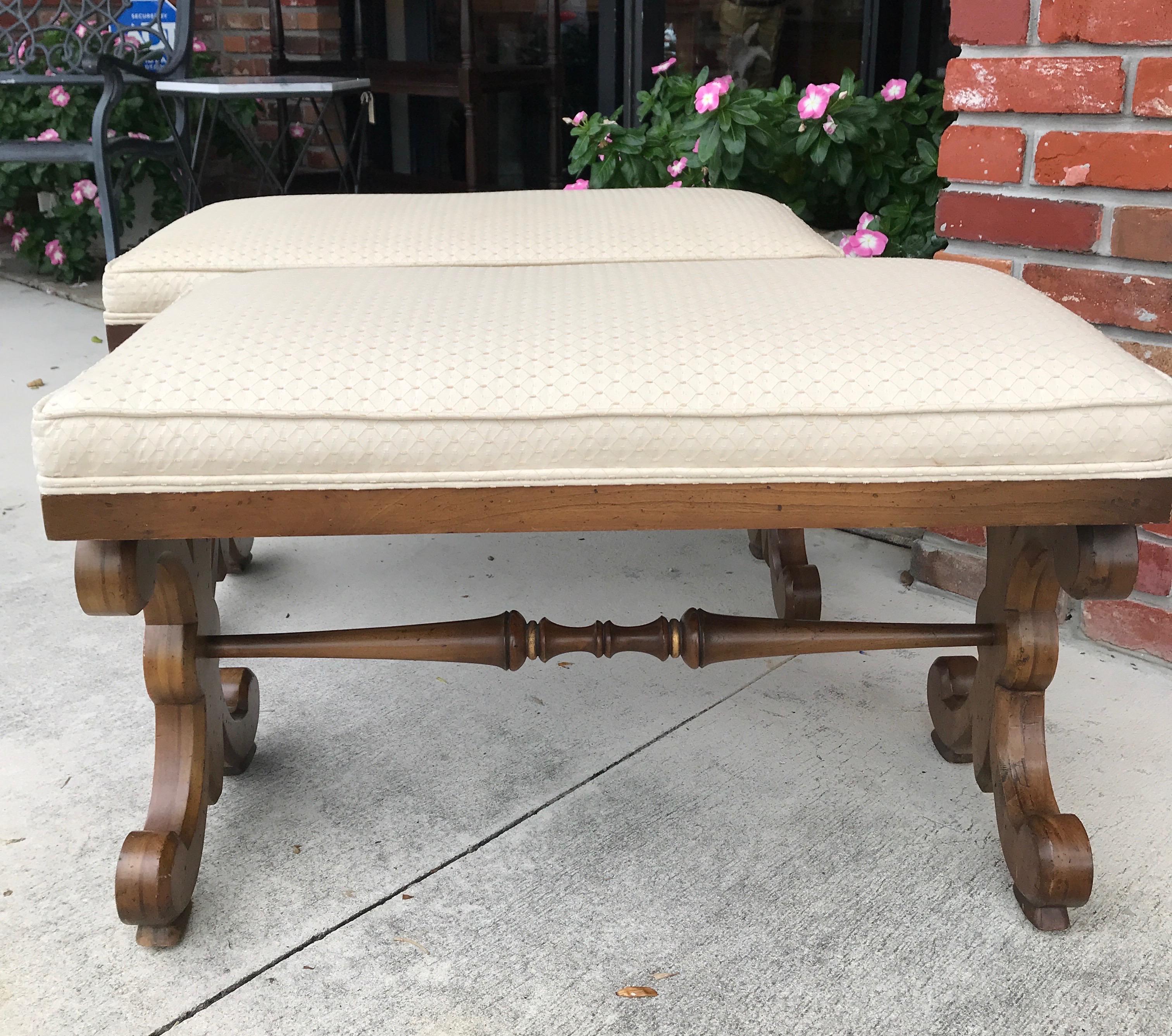 Pair of midcentury wood benches with fleur de lys style sides. Faint gilt detail
to outline. Box cushion in a bone color fabric.
