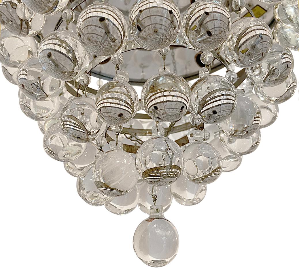 A pair of circa 1950's French flush-mounted light fixtures with round crystal pendants with three interior lights each. Sold individually.

Measurements:
Diameter: 13
