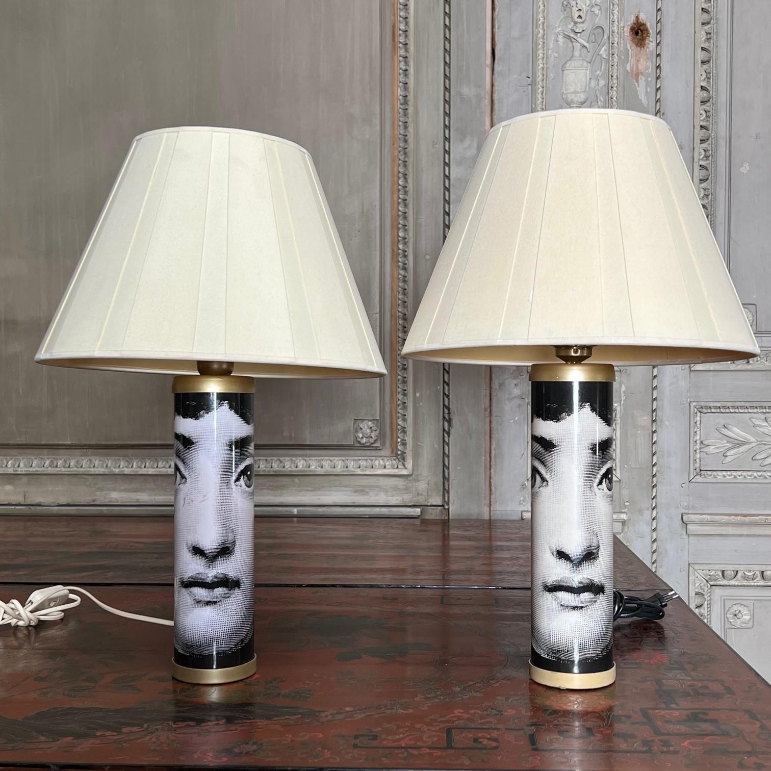 Pair of table lamps model designed by Pierro Fornasetti featuring the image of famed opera singer Lina Cavalieri screen printed around the base. Fornasetti label on base. These lamps will need to be wired, it currently has old European wiring that