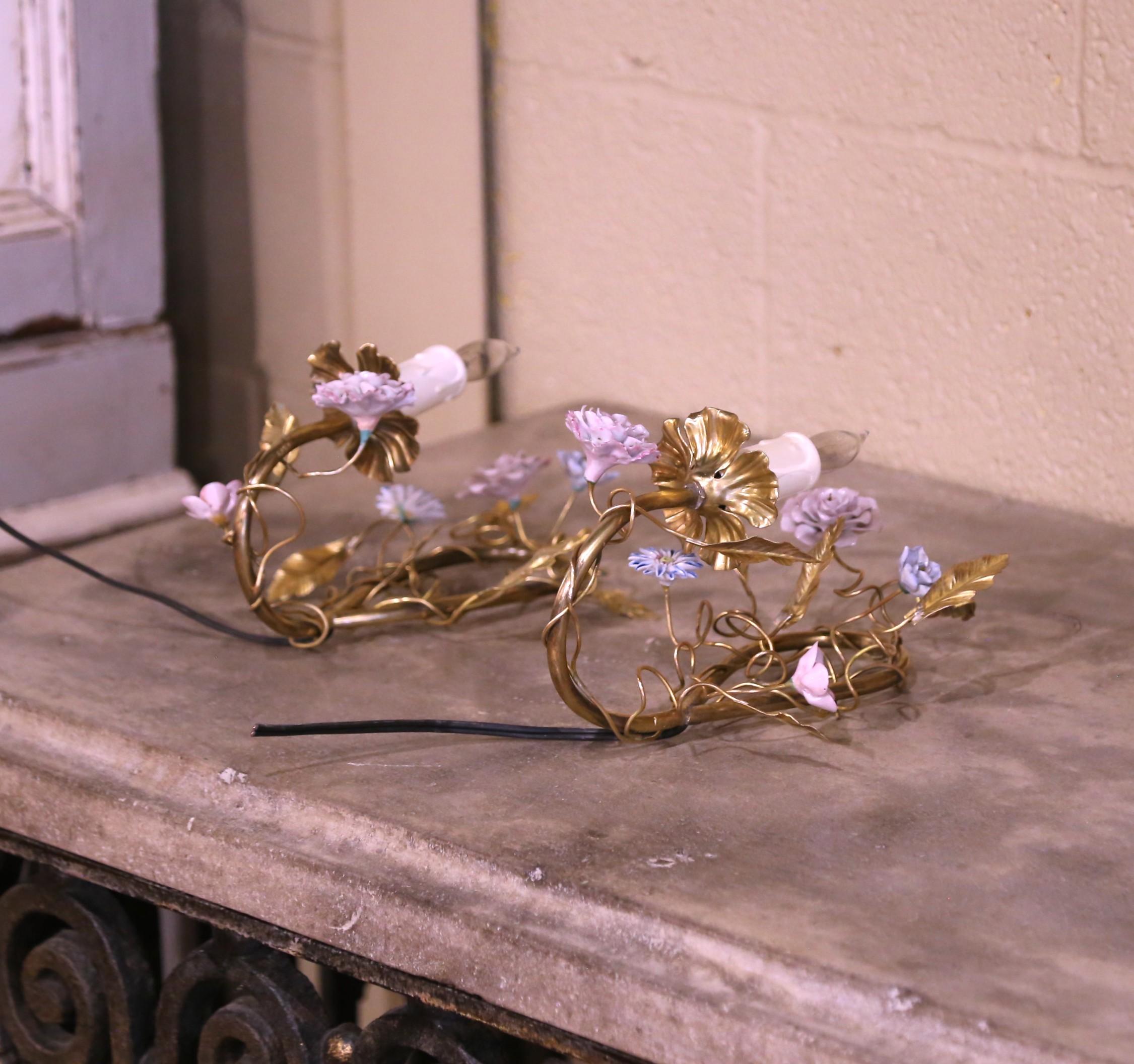 Dress a powder room or girl’s bedroom with this charming pair of vintage wall sconces adorned with floral motifs. Crafted in Paris, France circa 1950, each single-light fixture is decorated with delicate hand-painted porcelain flower blooms, evoking