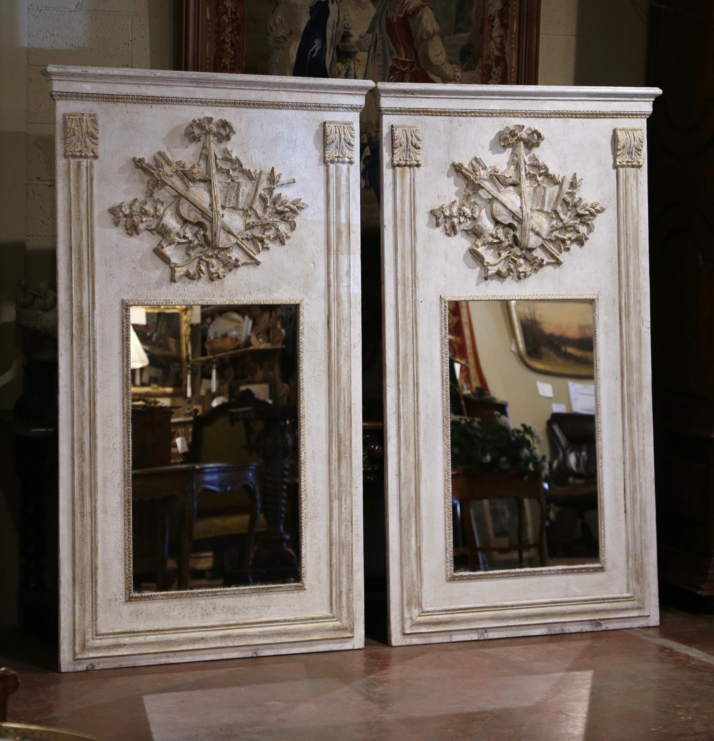 Decorate a living room, or even a master bathroom with this important pair of colorful vintage trumeaux mirrors. Crafted in France, circa 1950 and over 6.5 feet tall, each large trumeau is dressed at the pediment with a thick crown. Each wall piece