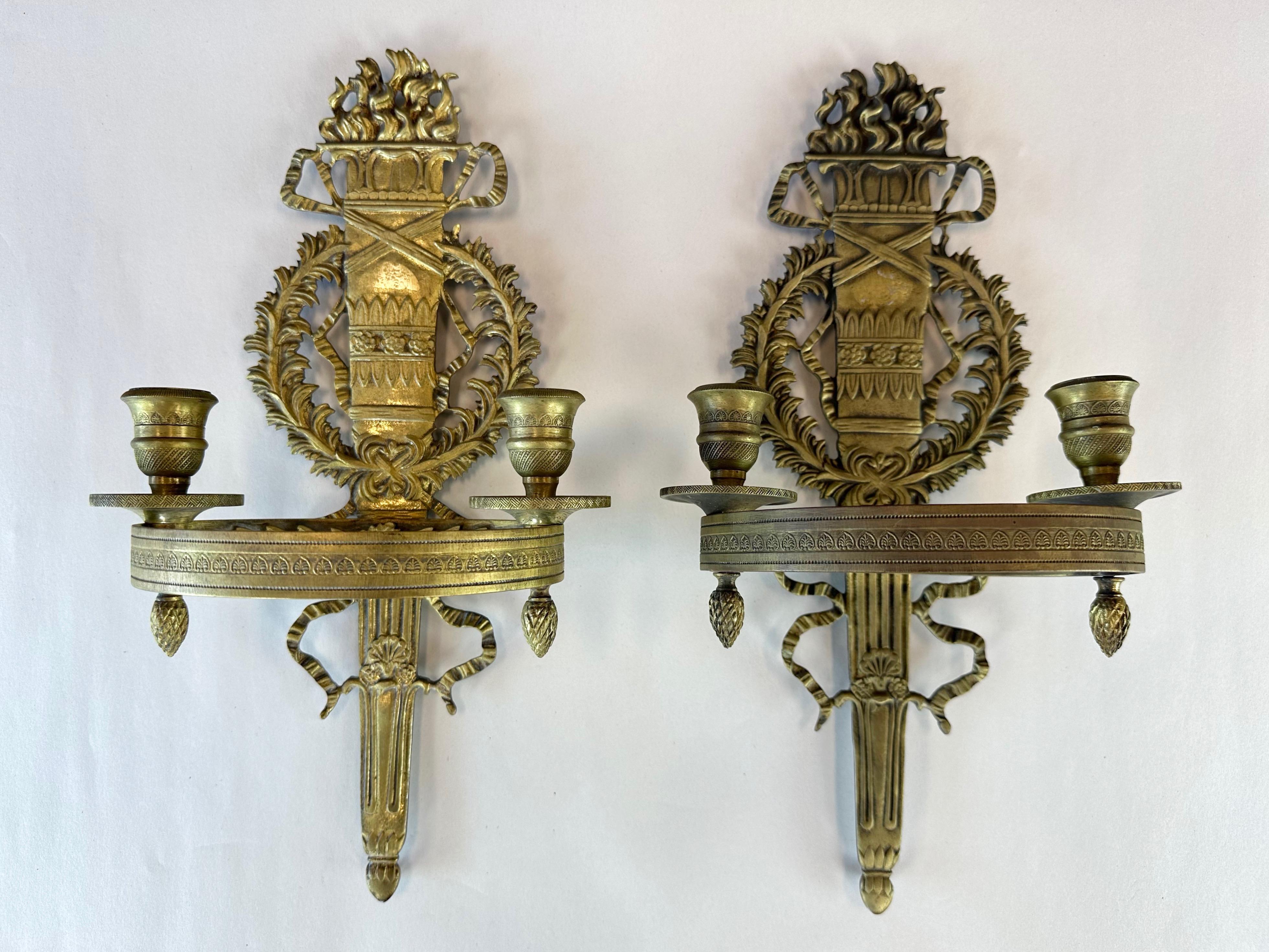 Ein Paar Zweikerzen-Leuchter aus Messing im französischen Empire-Stil der 1950er Jahre.

Durchgehend sehr detailliert. Die gegossene Form zeigt ein flammendes Fackelmotiv, das mit einem Akanthuskranz und gewellten Bändern verziert ist. Das
