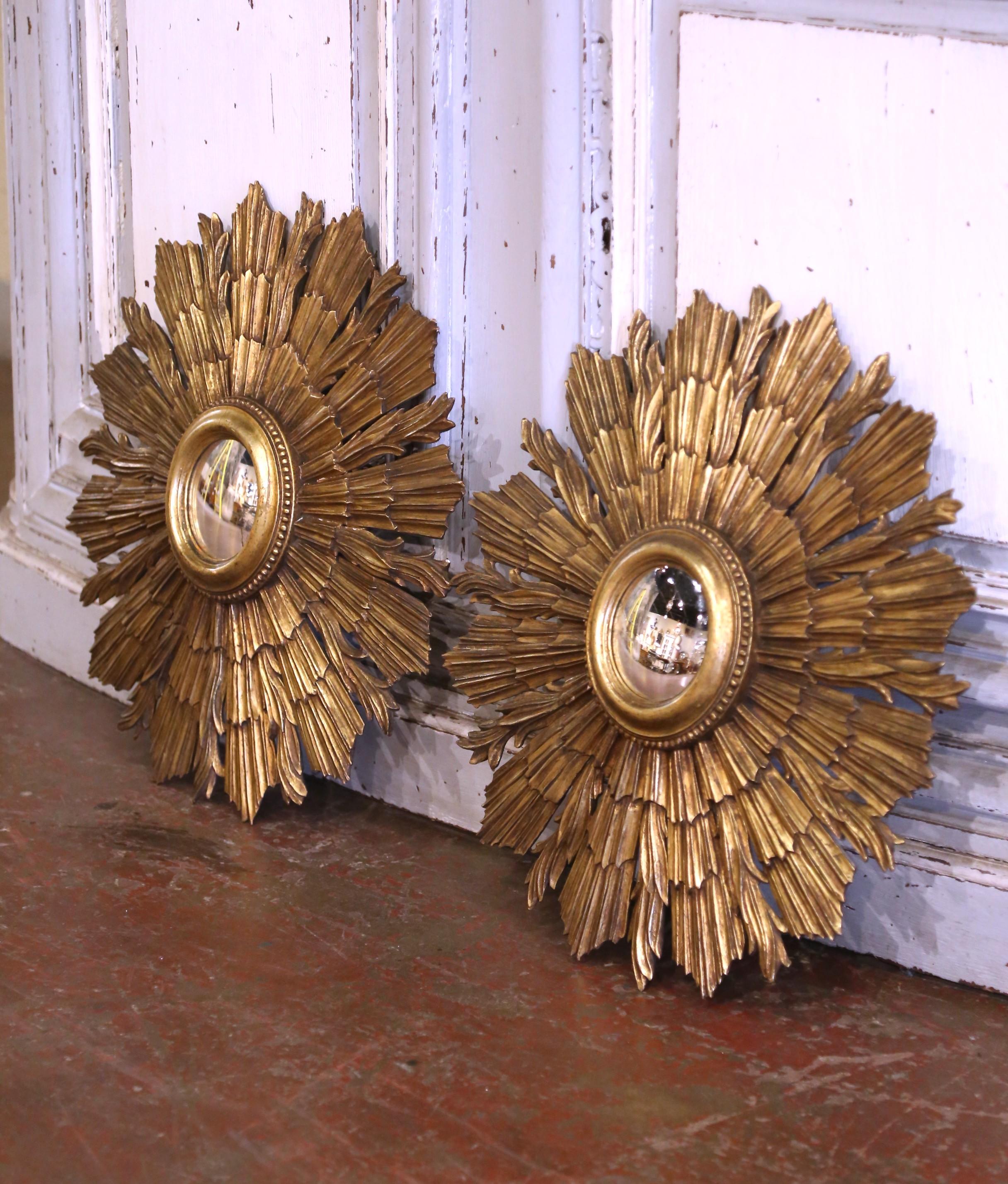 Ajoutez une élégance céleste à vos murs avec cette paire saisissante de miroirs en forme de soleil de style antique. Fabriqué en France vers 1960, chaque miroir est sculpté à la main dans du bois et recouvert d'une patine dorée éclatante, évoquant
