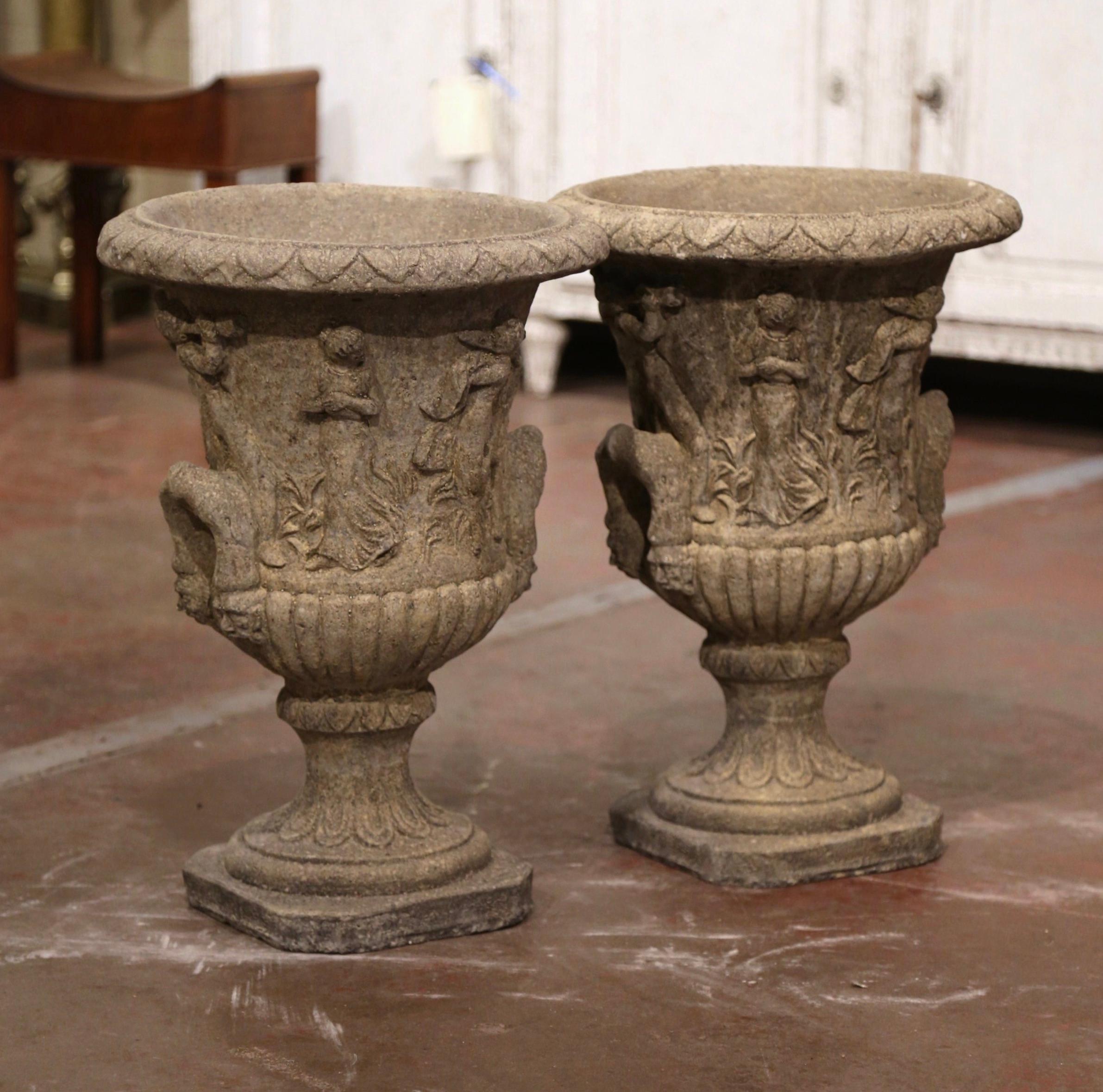 Decorate a patio or garden with this elegant pair of antique outdoor planters. Carved in France, circa 1970, each stone jardinière stands on a square base with cut corners over a short pedestal decorated with acanthus leaf motifs. Dressed with side
