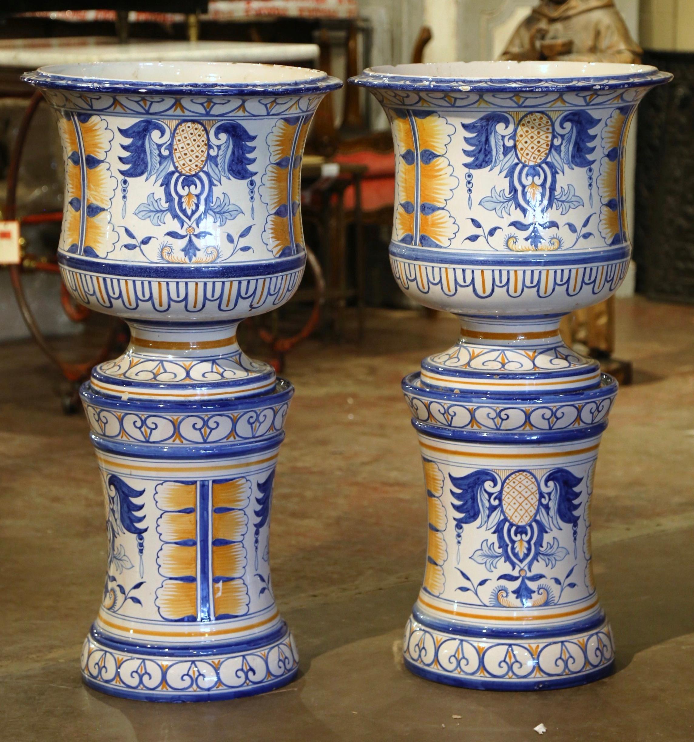 Bring colors to any room with these elegant, antique faience planters with matching bases. Crafted in Nevers, France, circa 1940, and signed by Montagnon, each large, ceramic cache-pot stand on a tall circular base. Each round vessel features