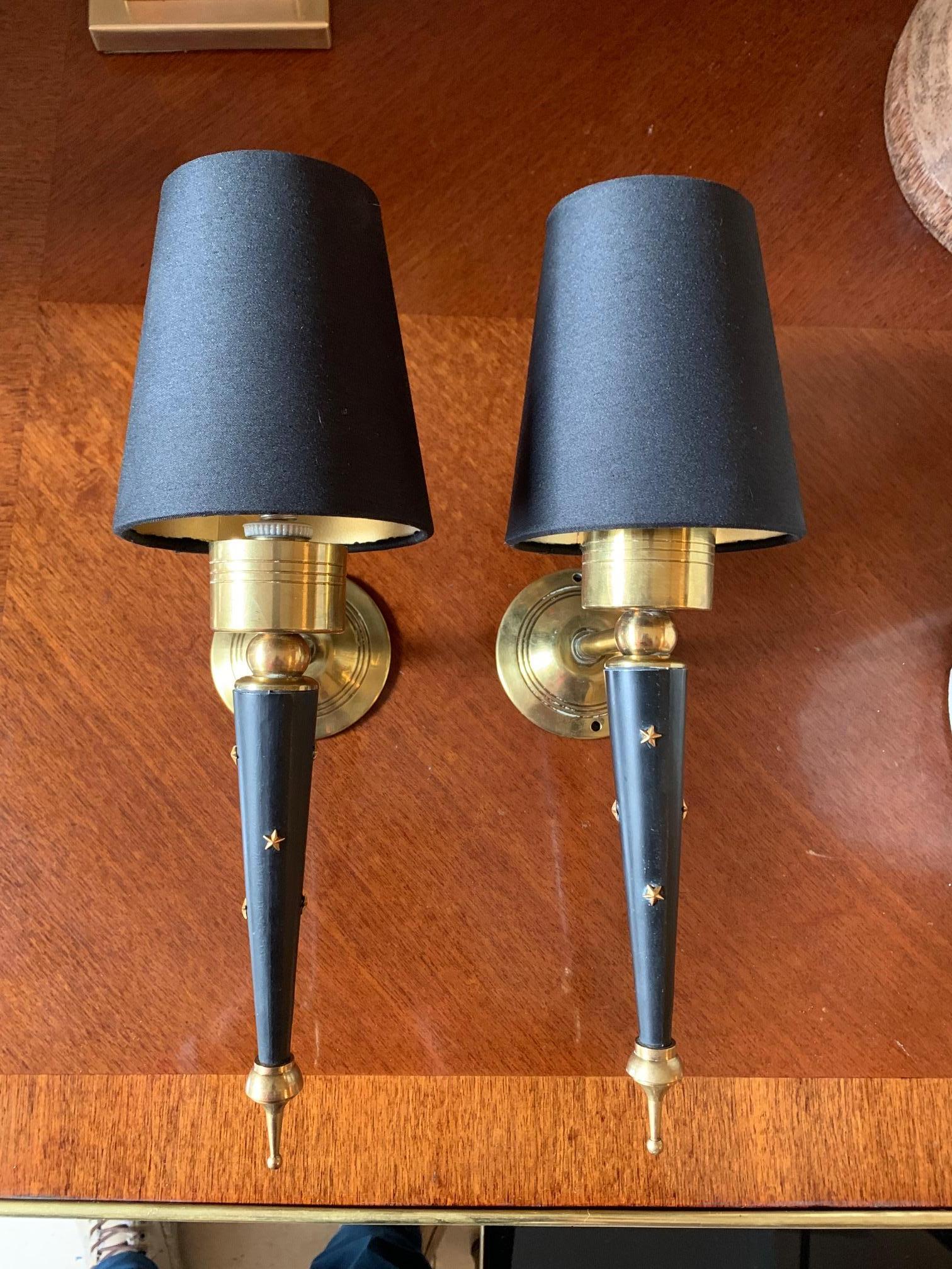 Pair of 1950s French midcentury wall sconces, in lacquered metal and golden brass, main part decorated with brass stars, the lampshade is black and gold interior
Electrical installation rewired.
 