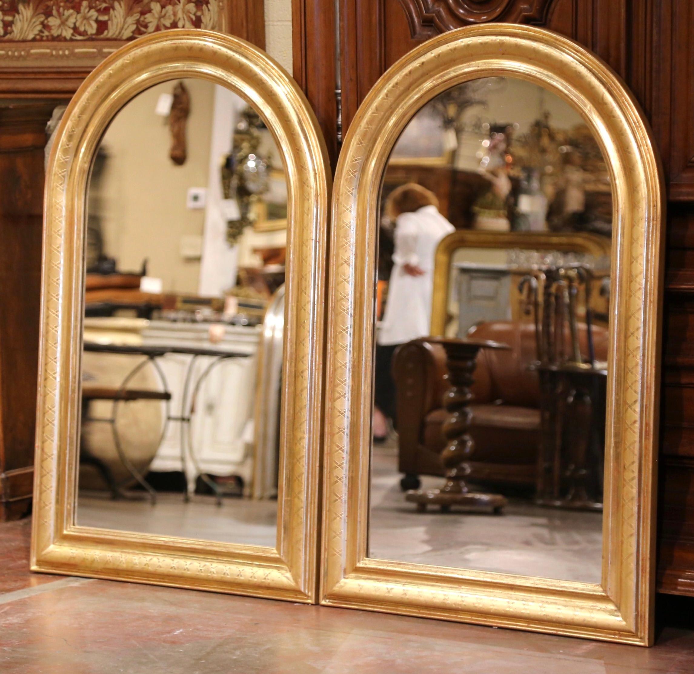 Decorate a master bathroom with this elegant pair of wall mirrors! Crafted in France, circa 1970, each antique mirror has traditional, timeless lines with an elegant arched top. The frame is decorated with a luxurious gold leaf finish over discrete
