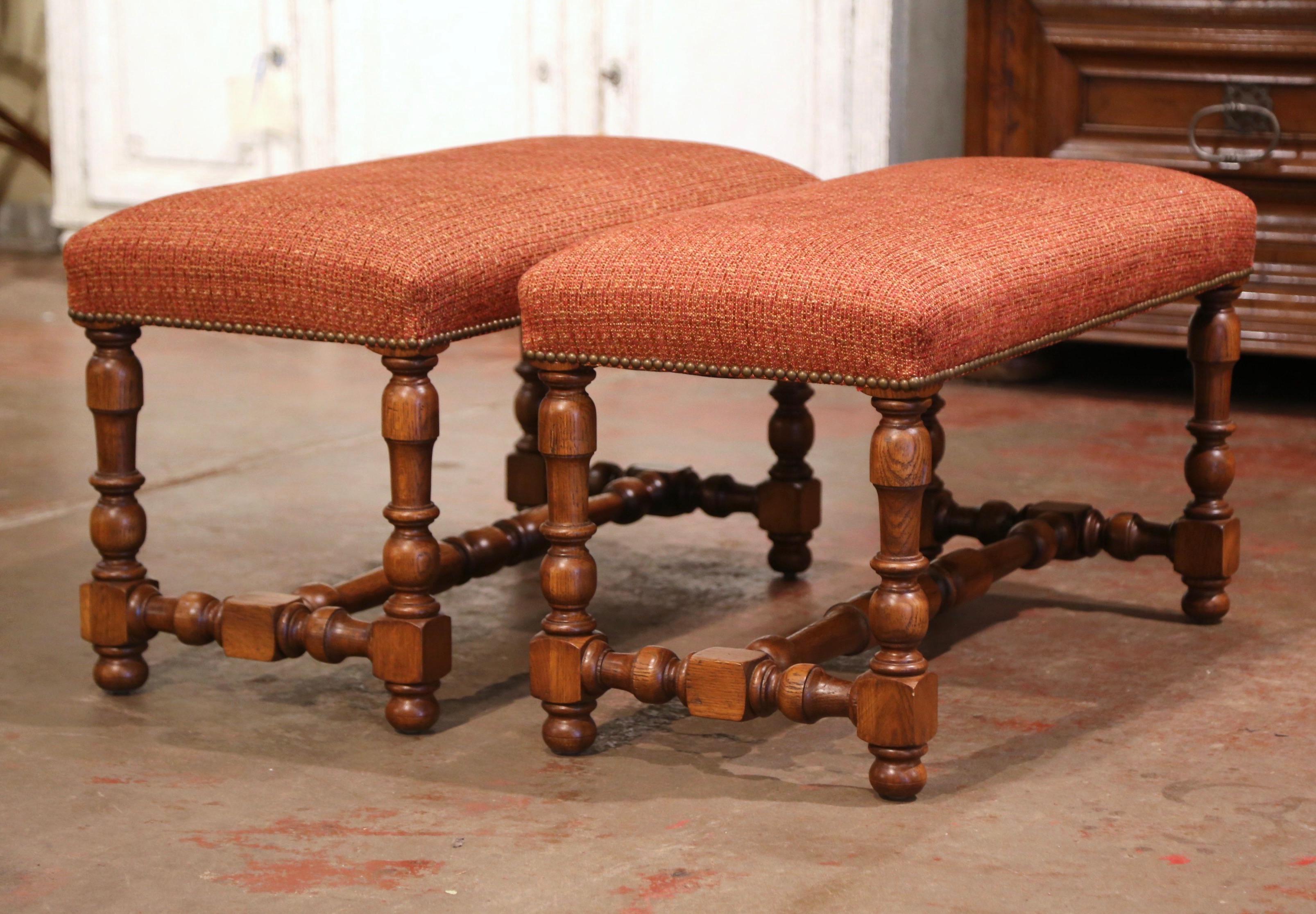 Decorate a hall way or add extra seating to a living room with this elegant pair of vintage benches. Crafted in France circa 1960 and built of solid oak, each seating features four delicately carved, turned legs with a matching stretcher. The top
