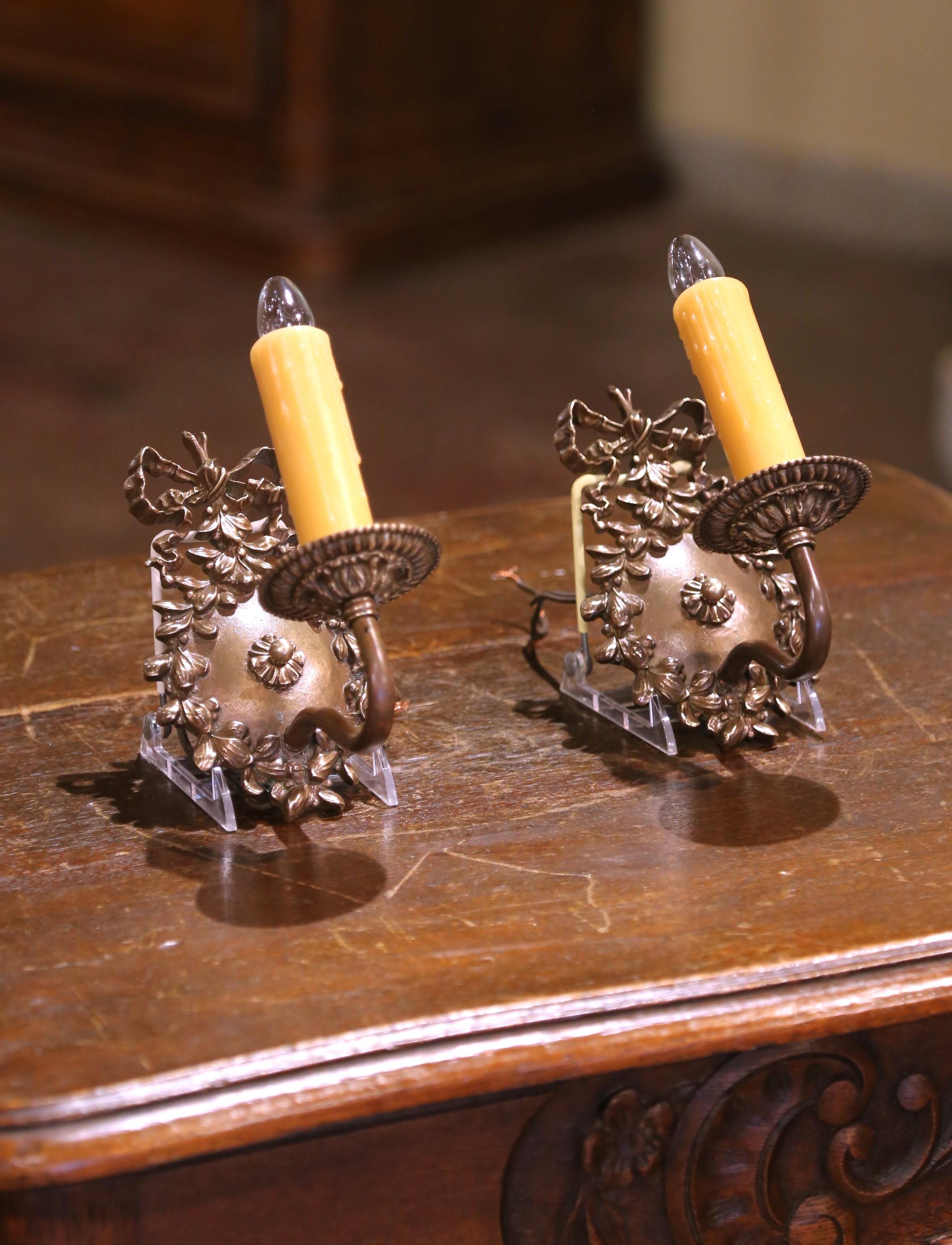 Eleganza per i tuoi interni con questa elegante coppia di applique in bronzo vintage in stile Luigi XV. Realizzata in Francia intorno al 1950, ogni applique a una luce presenta una finitura in bronzo patinato e un design scultoreo a fogliame