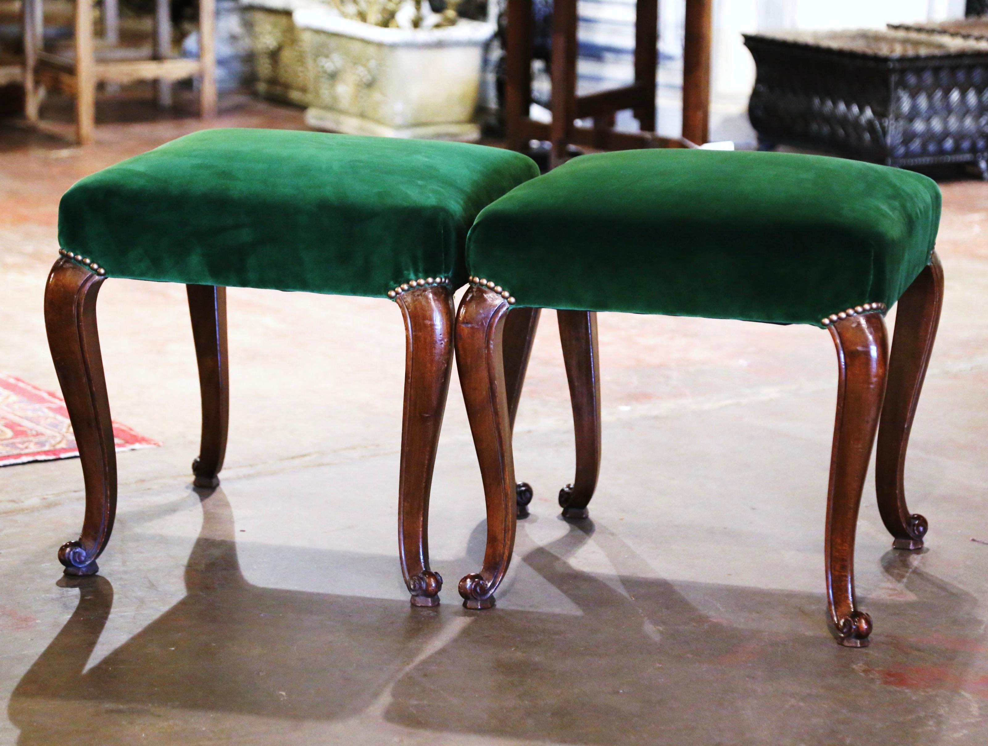 These elegant antique stools were crafted in southern France circa 1950. Standing on cabriole legs ending with escargot feet, each stool features a straight apron. The seat is newly upholstered with a wonderful dark green velvet fabric embellished