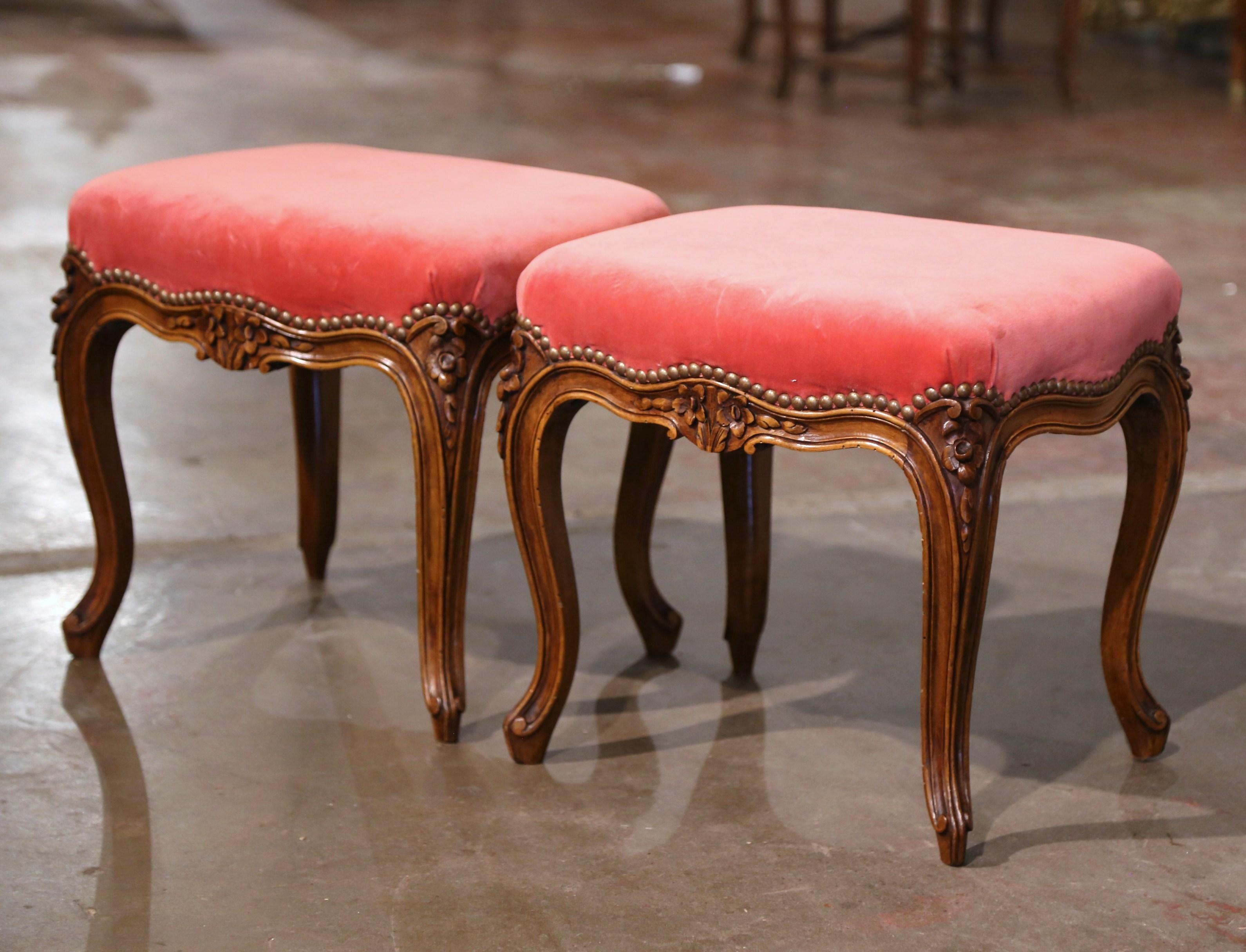 These elegant antique stools were crafted in Provence, France circa 1950. Standing on cabriole legs ending with scroll feet and decorated with carved leaf and floral motifs at the shoulder, each stool features a bombe scalloped apron embellished