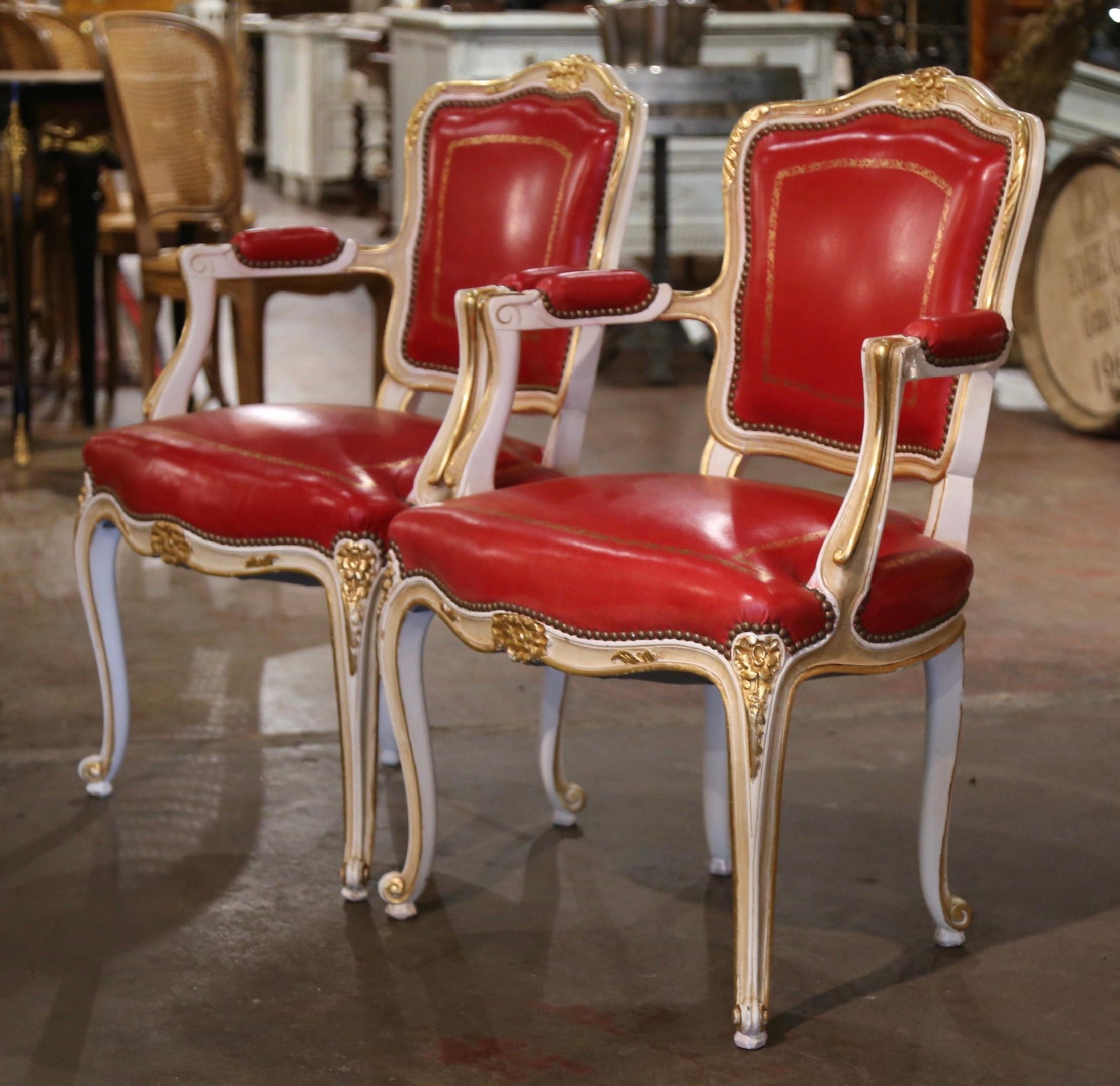 Add a pop of color to your office or den with this elegant pair of antique painted and gilt armchairs. Crafted in Provence France circa 1960, each chair stands on cabriole legs decorated with carved floral motifs at the shoulder, and ending with