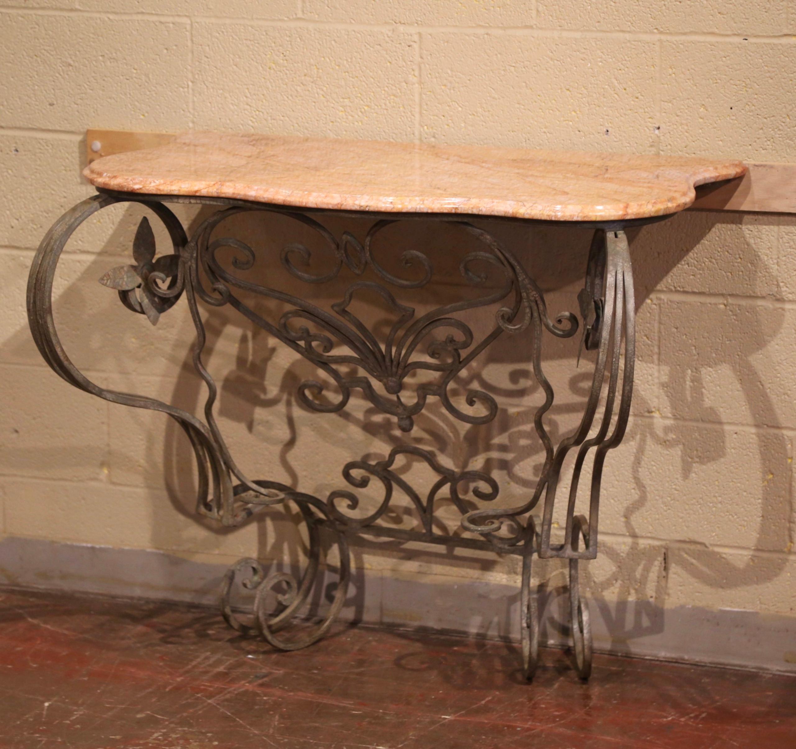 Decorate an entryway or hallway with this elegant pair of antique consoles. Crafted in France circa 1960, each table stands on double iron cabriole legs, connected at the base with an intricate bottom stretcher. The bombe front is embellished with