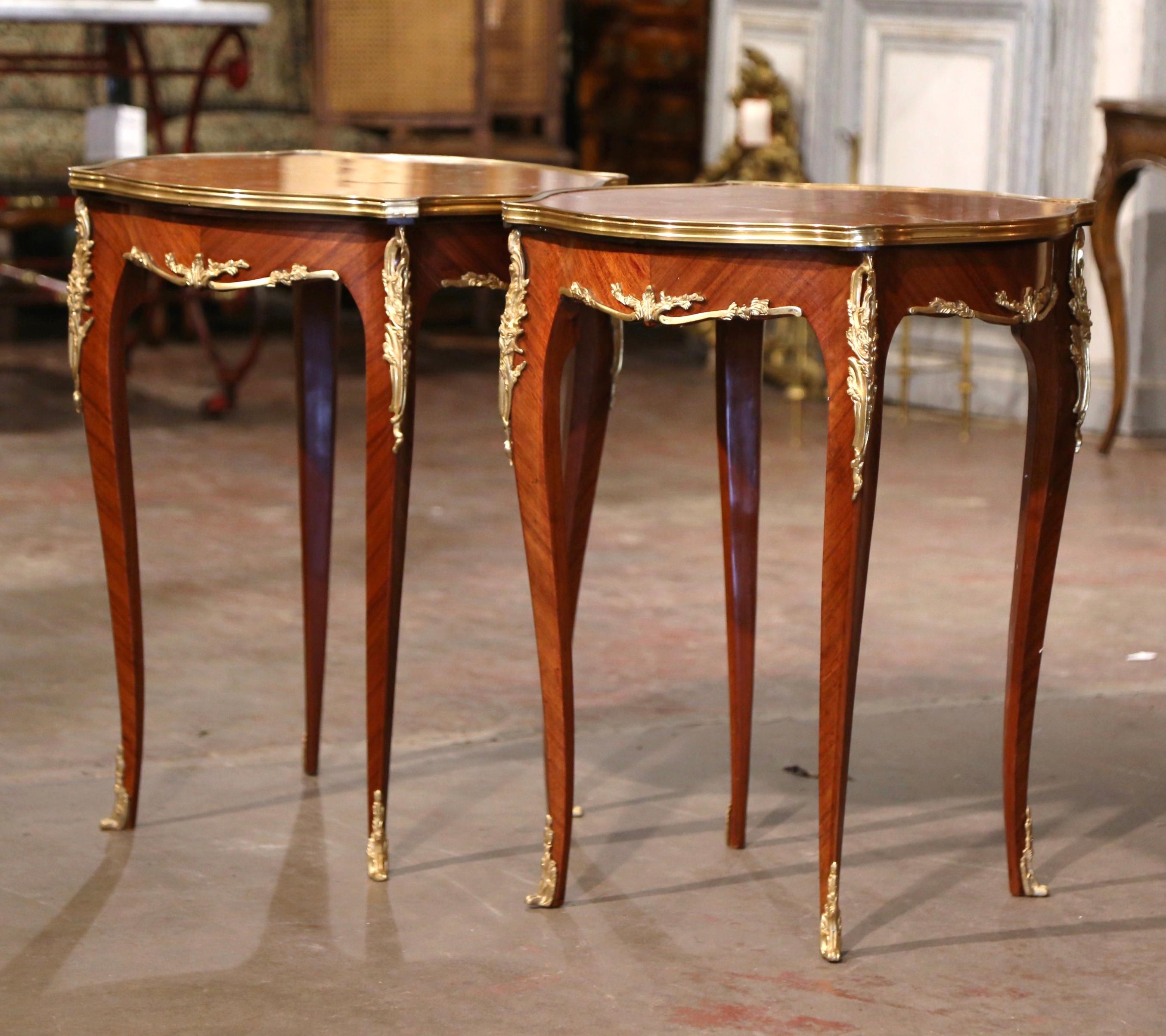 Decorate a living room or den with this elegant pair of antique side tables. Crafted in France, circa 1960 and square in shape with bombe sides, each table stands on cabriole legs embellished with bronze dore mounts at the shoulder, and ending with