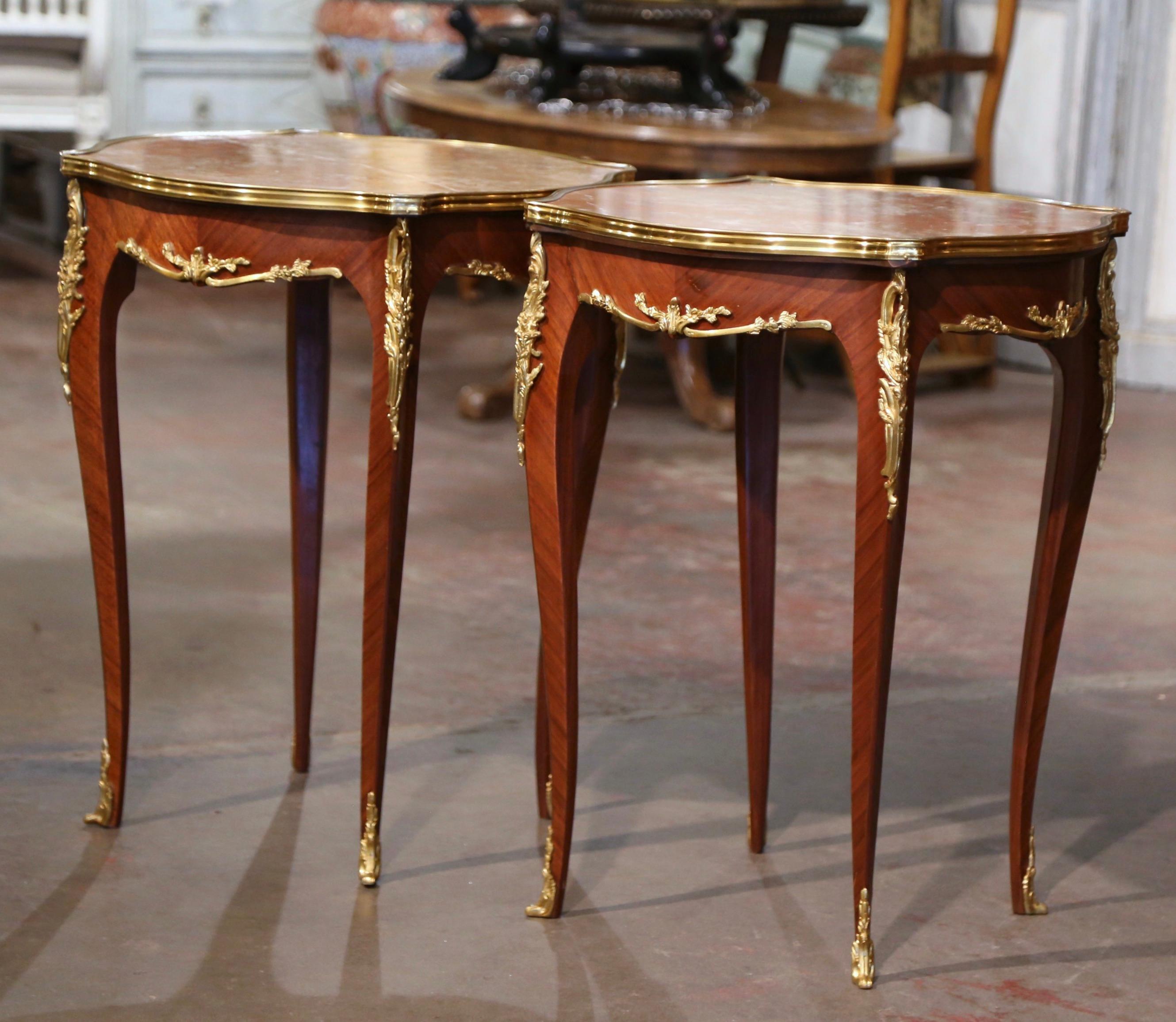 Decorate a living room or den with this elegant pair of antique side tables. Crafted in France, circa 1960 and square in shape with bombe sides, each table stands on cabriole legs embellished with bronze dore mounts at the shoulder, and ending with