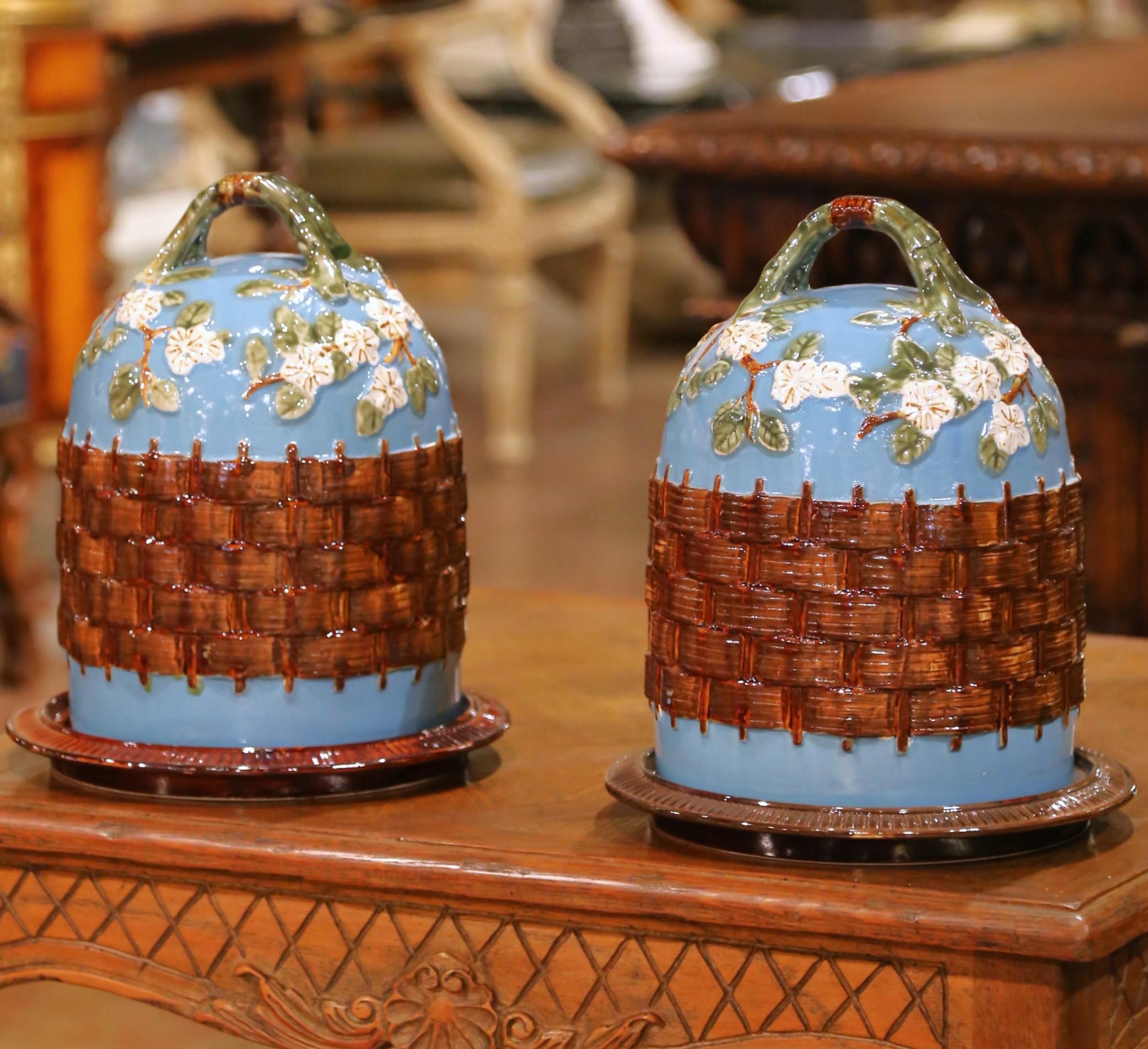 Questa rara coppia di cupole da pasticceria o da formaggio in stile maiolica è stata realizzata in Francia intorno al 1960. Ogni set di Barbotine in ceramica comprende un piatto circolare con bordo a coste rifinito con un ricco smalto marrone