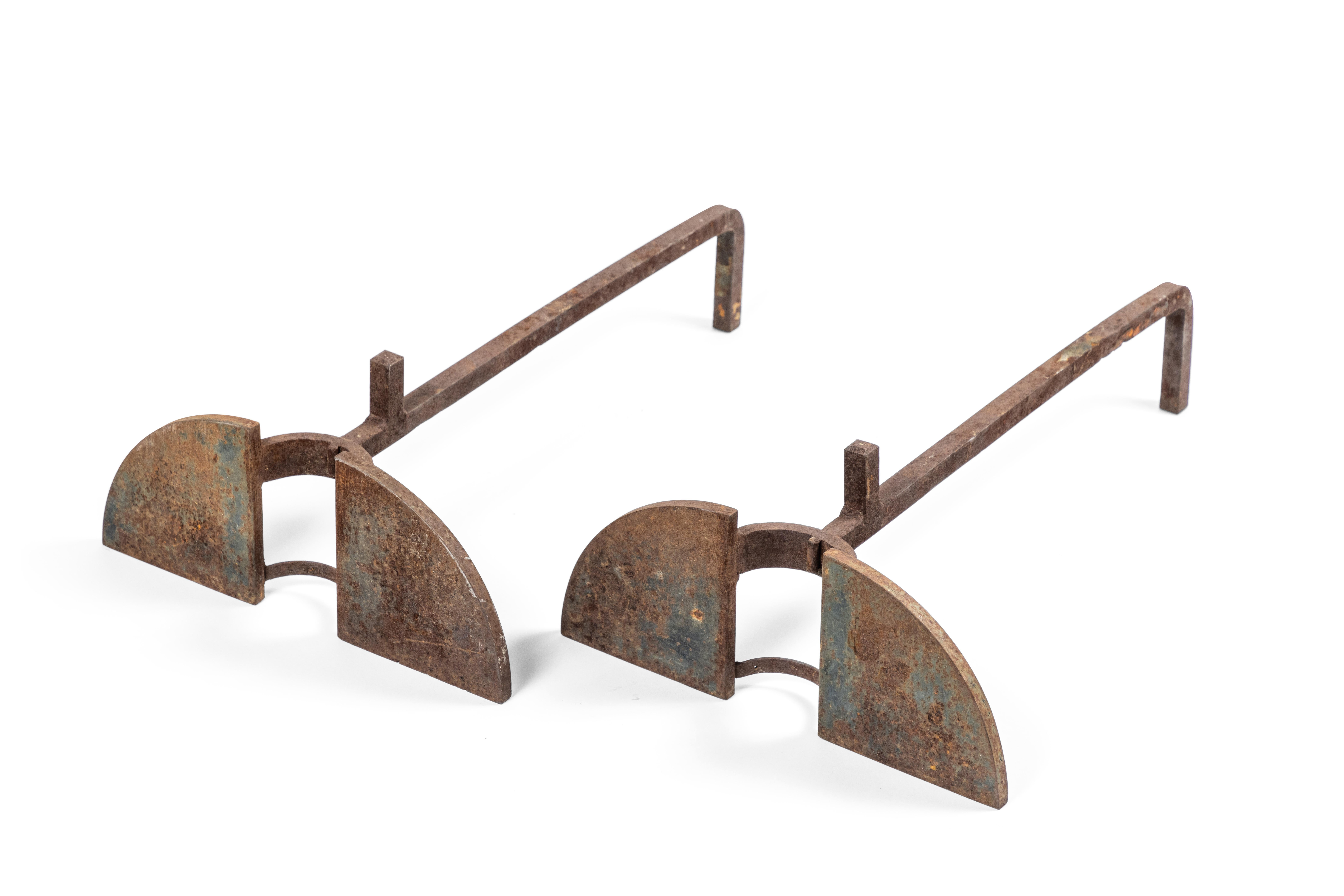 Incredible pair of modernist andirons in forged iron. The pair have a lovely natural rust patina.
