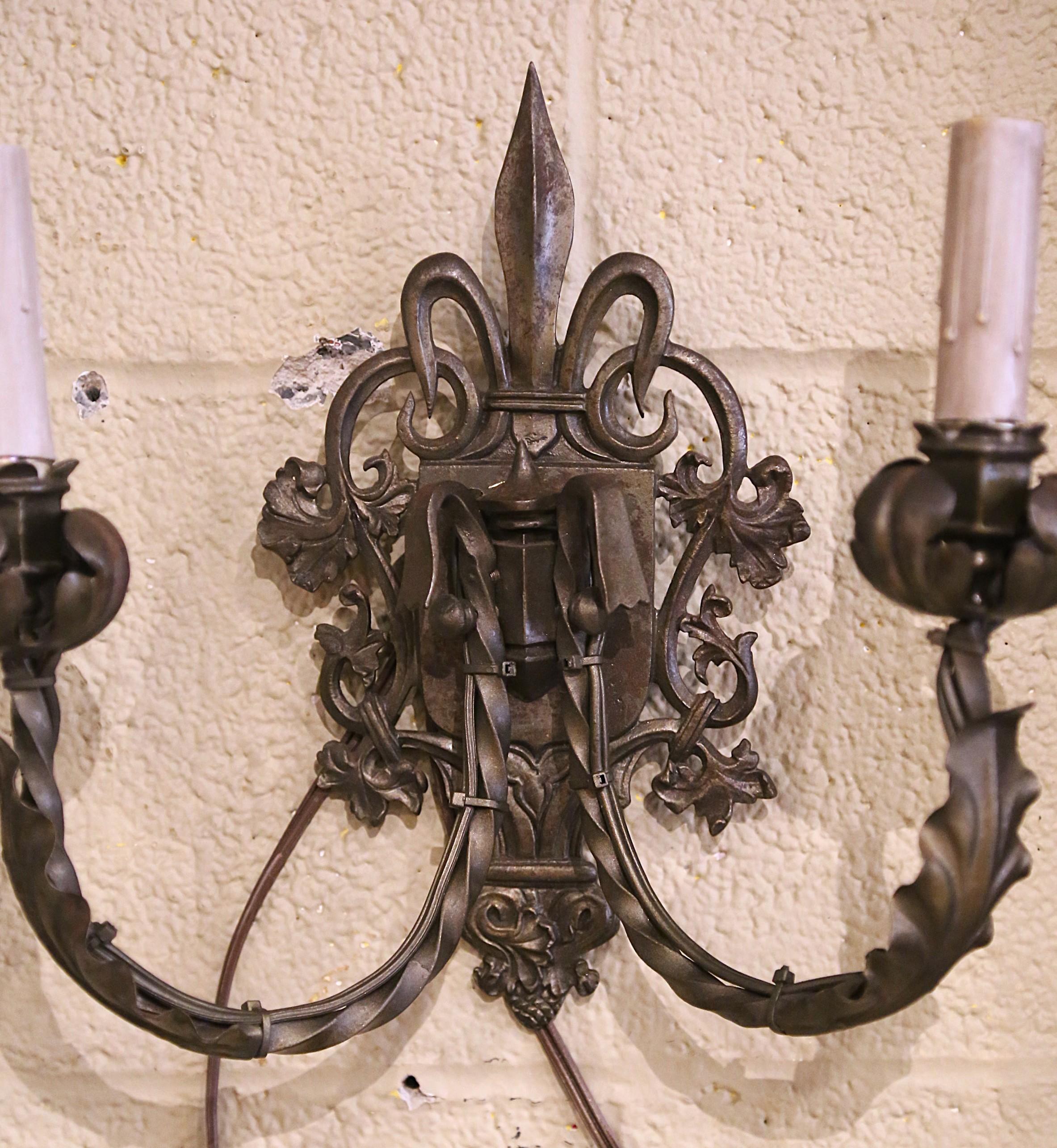 Francese Coppia di appliques a due luci in metallo della metà del secolo scorso con motivo Fleur-de-Lys in vendita