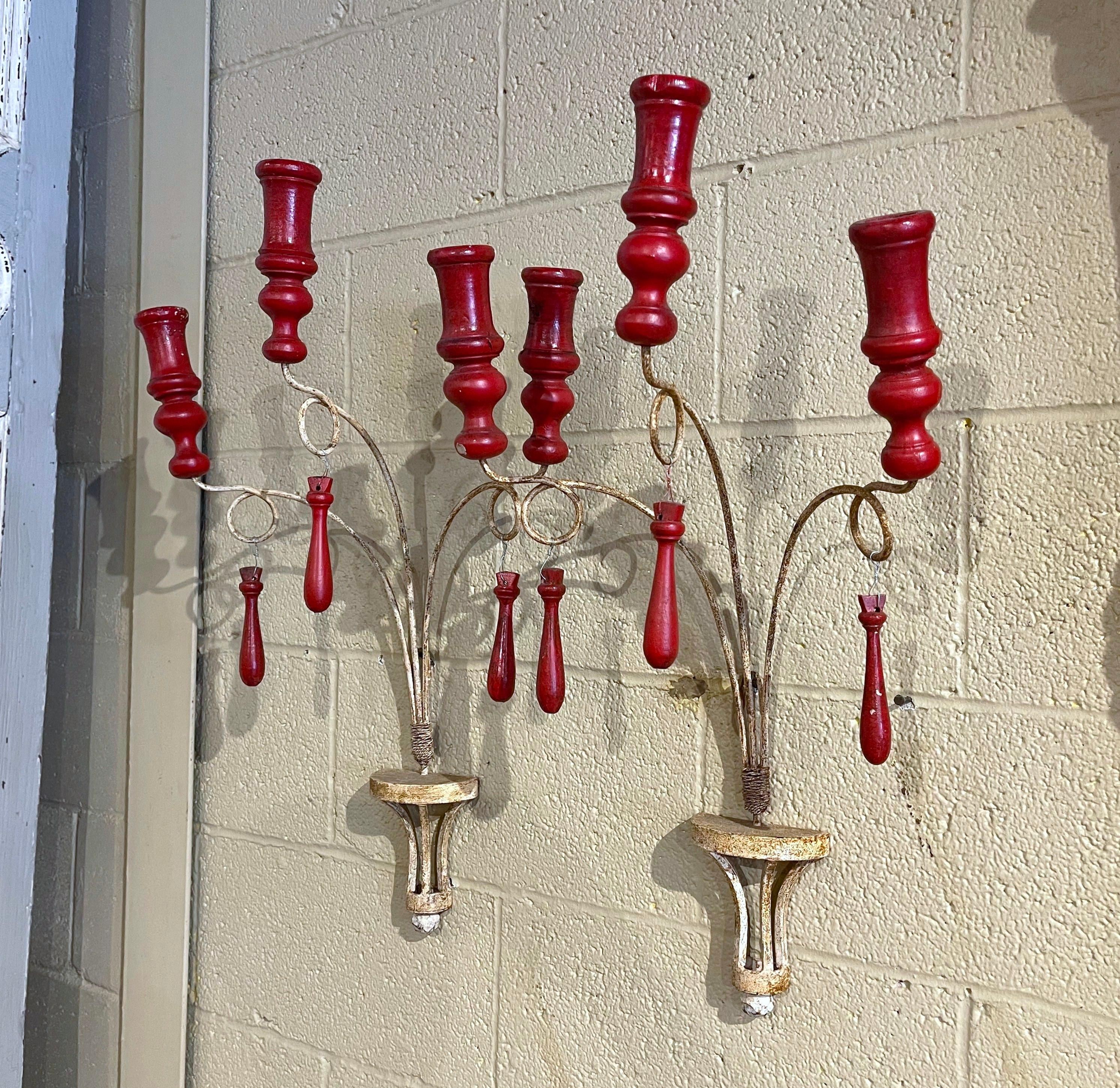 Decorate a powder room or an entry with these elegant and colorful antique candle holders. Crafted in France, circa 1960, each wall fixture features three iron scrolled arms roped together at the base, and decorated with carved wooden finials. Each