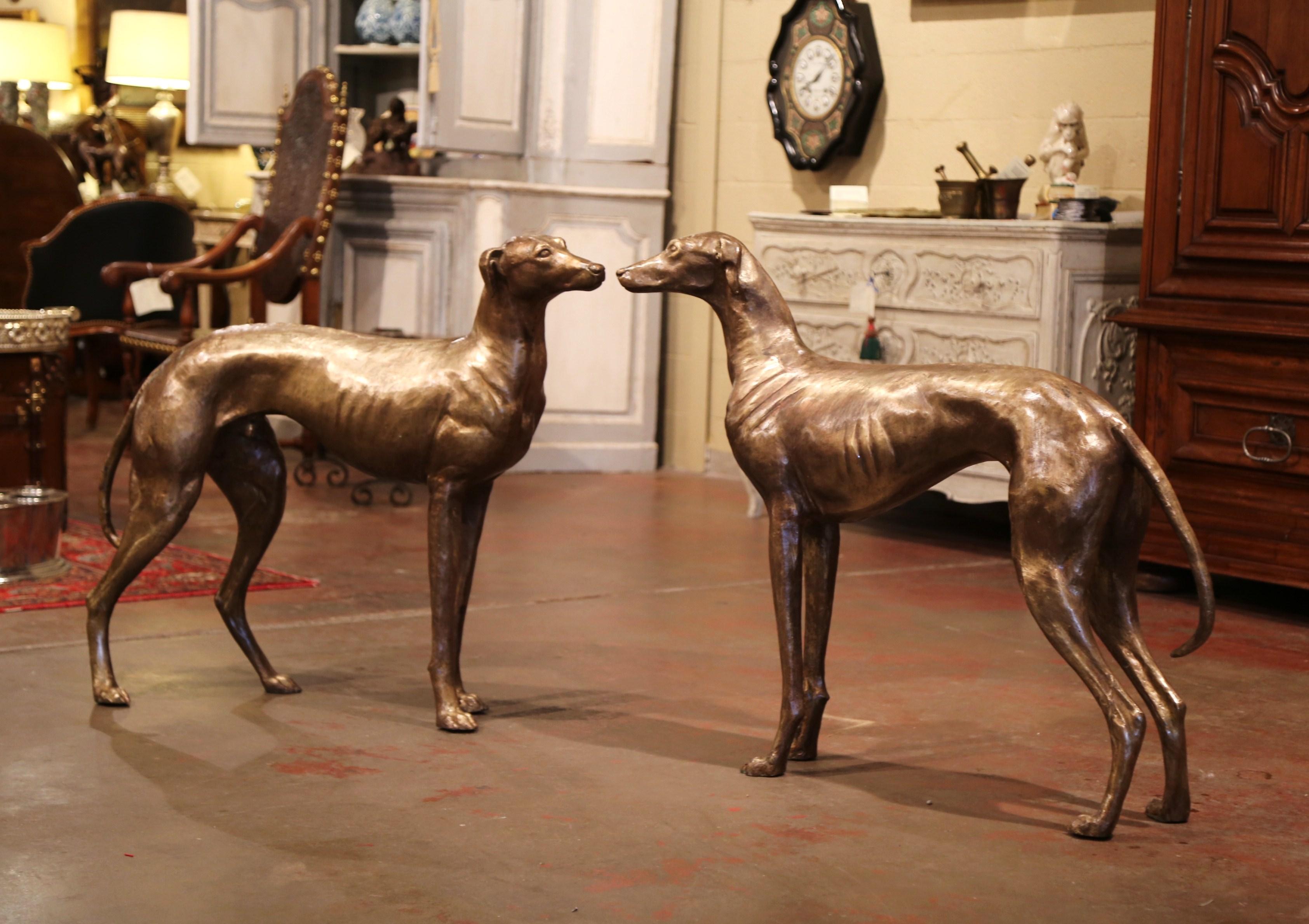 These tall Classic dog sculptures were crafted in France, circa 1960. Made of bronze, the stately, vintage Greyhounds have wonderful expression with great details. The sculpted canines have a weathered patinated finish and could be used inside or