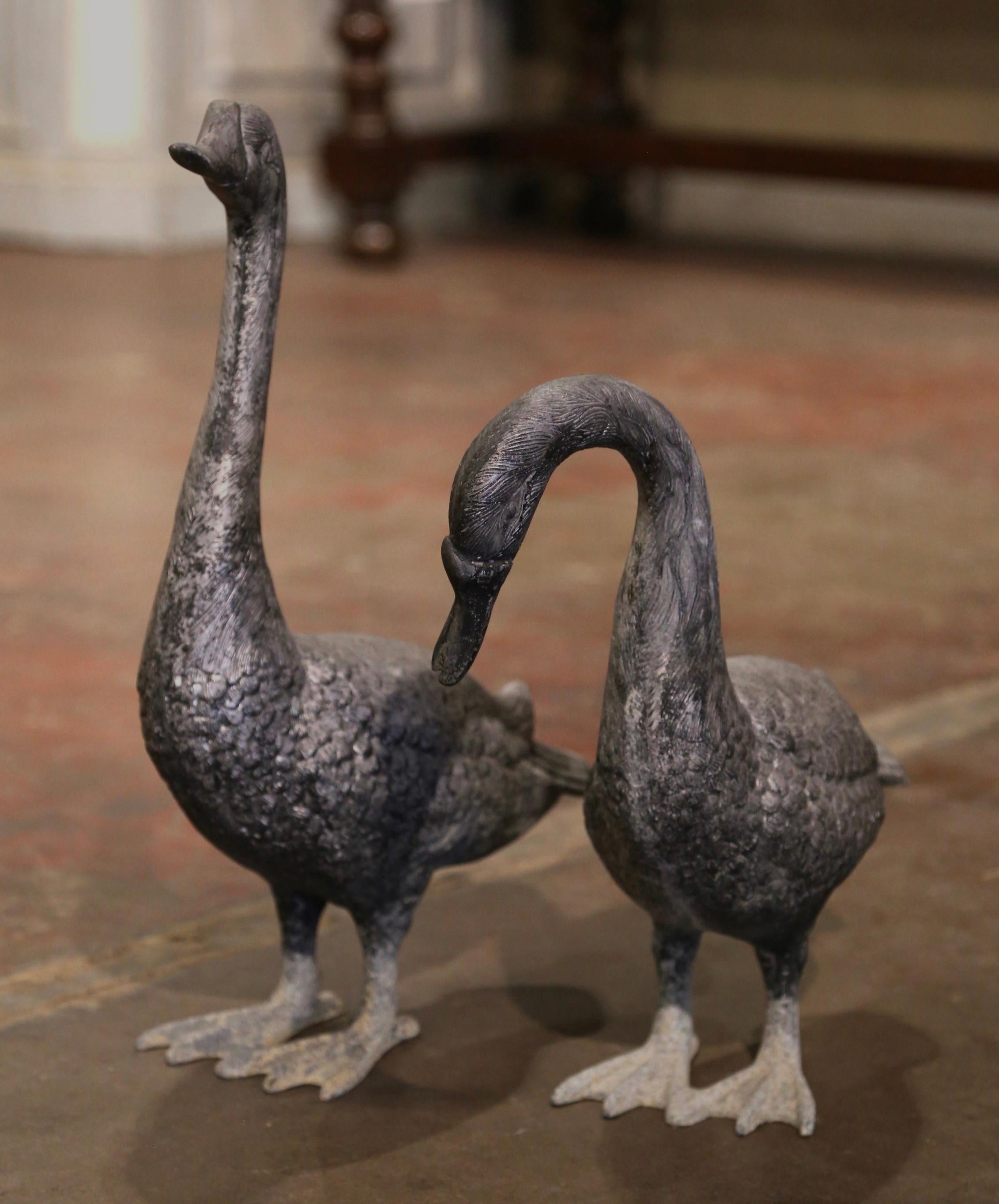 Decorate a patio or garden with these geese garden sculptures. Crafted in France circa 1970 and made of metal, the sculpture depict a pair of geese standing. Both bird decor are in excellent condition and adorn a rich and natural patinated and