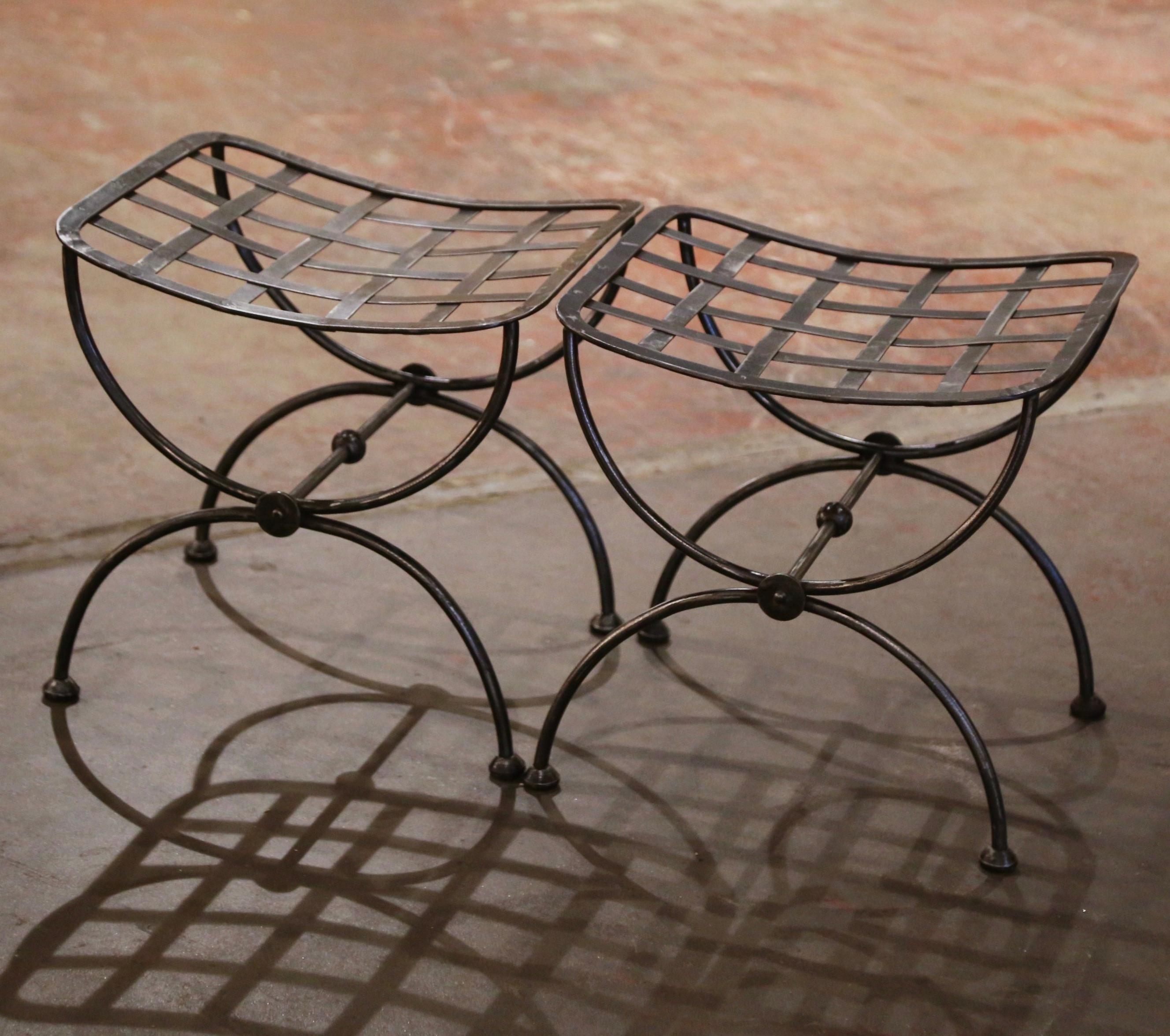 Crafted in France circa 1960 and made of wrought iron, each antique stool stands on forged Dagobert legs ending with round feet, and connected with a decorative bottom stretcher. The curved comfortable seat has an intricate weave decor throughout.