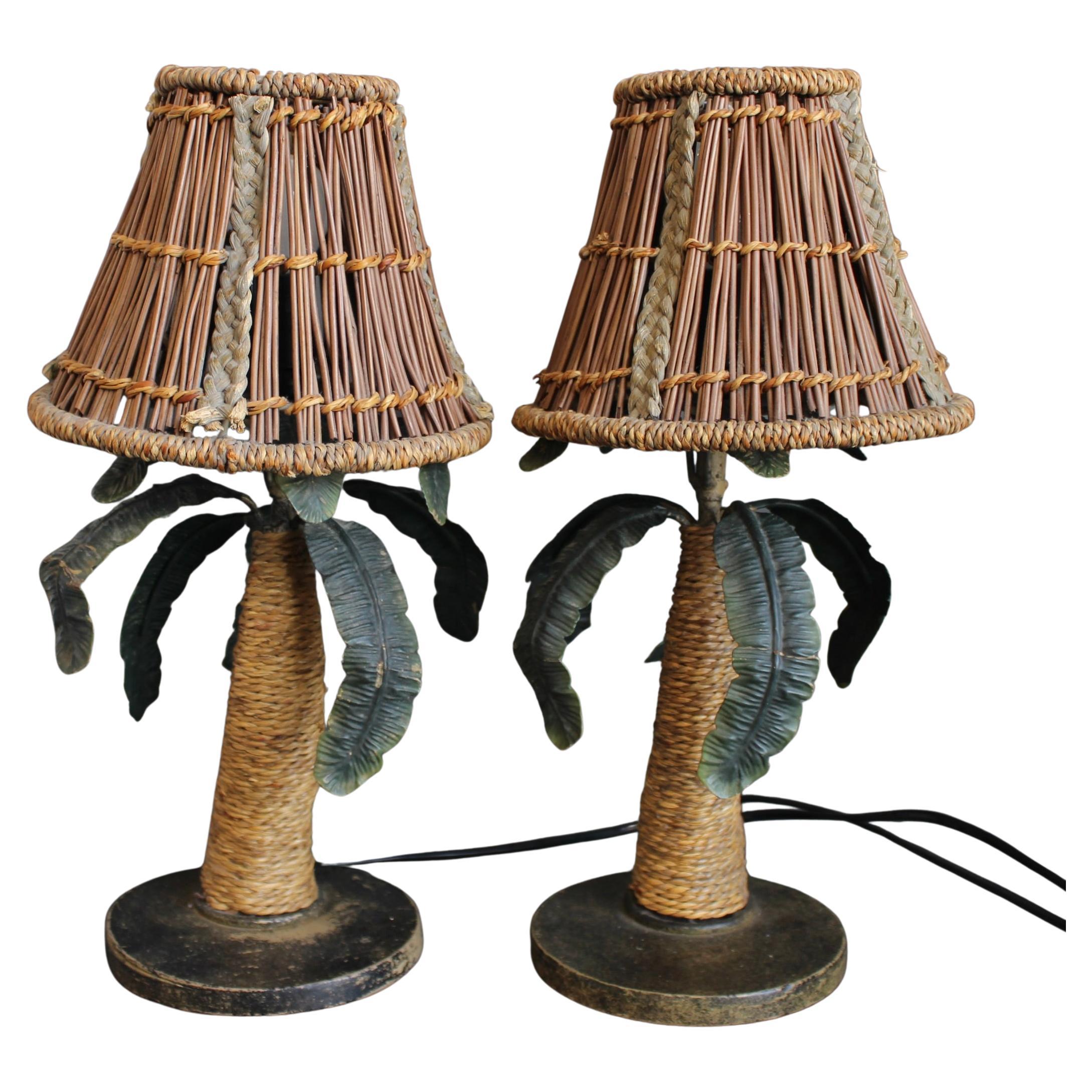 Pair of Mid-Century French tôle palm tree table lamps (circa 1960s). Discovered in the South of France, they are delightful and uplifting nature-themed table lighting fixtures with rattan-wrapped trunks and rattan shades. Supporting the lamps are