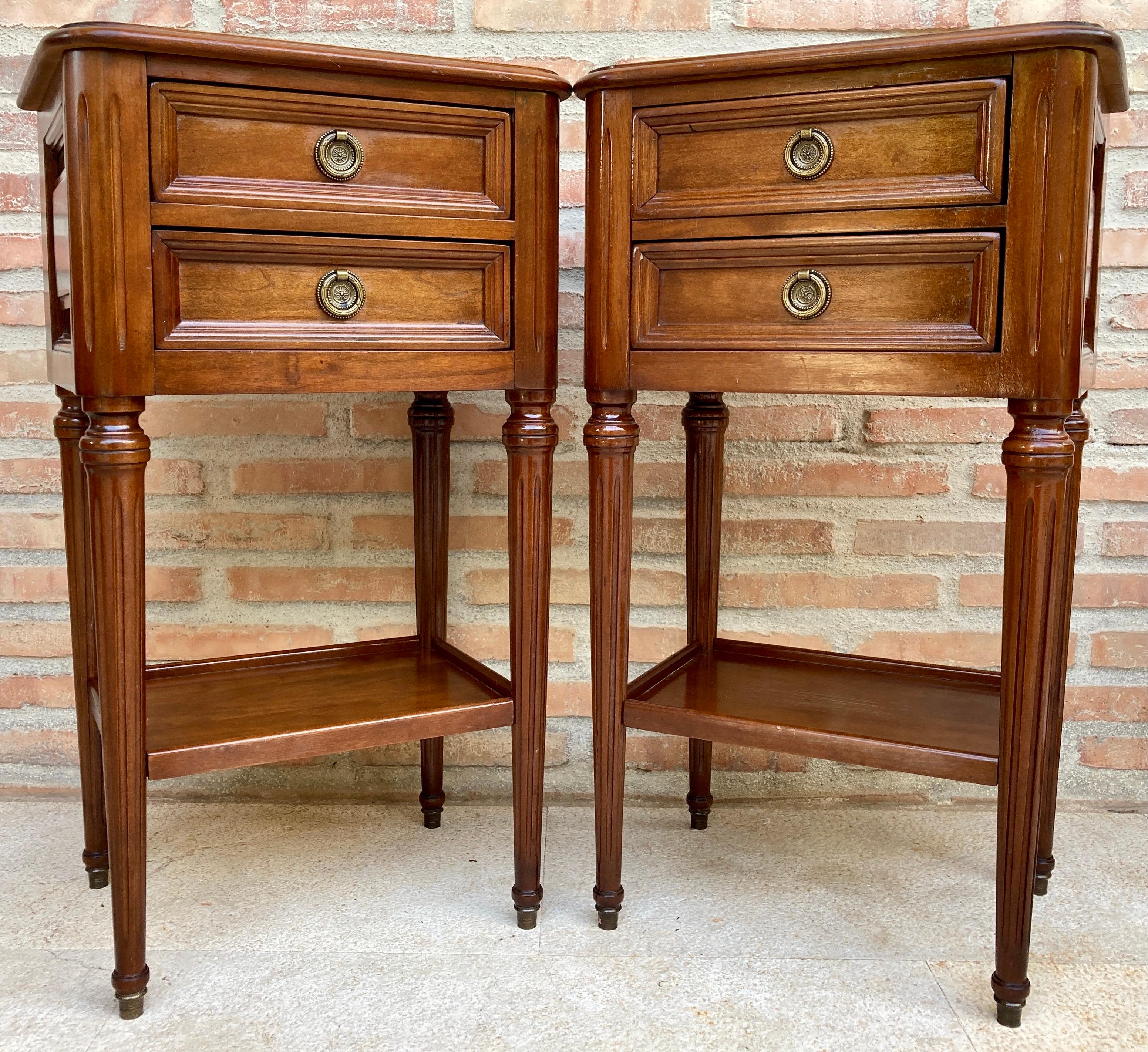 Pair of mid-century French Walnut Nightstands with 2 drawers and 1 low shelf. 
Beautiful pair of French bedside tables in an elegant style, with 2 small front drawers and 2 delicate brass handles. 
It has a shelf at the bottom of the table.