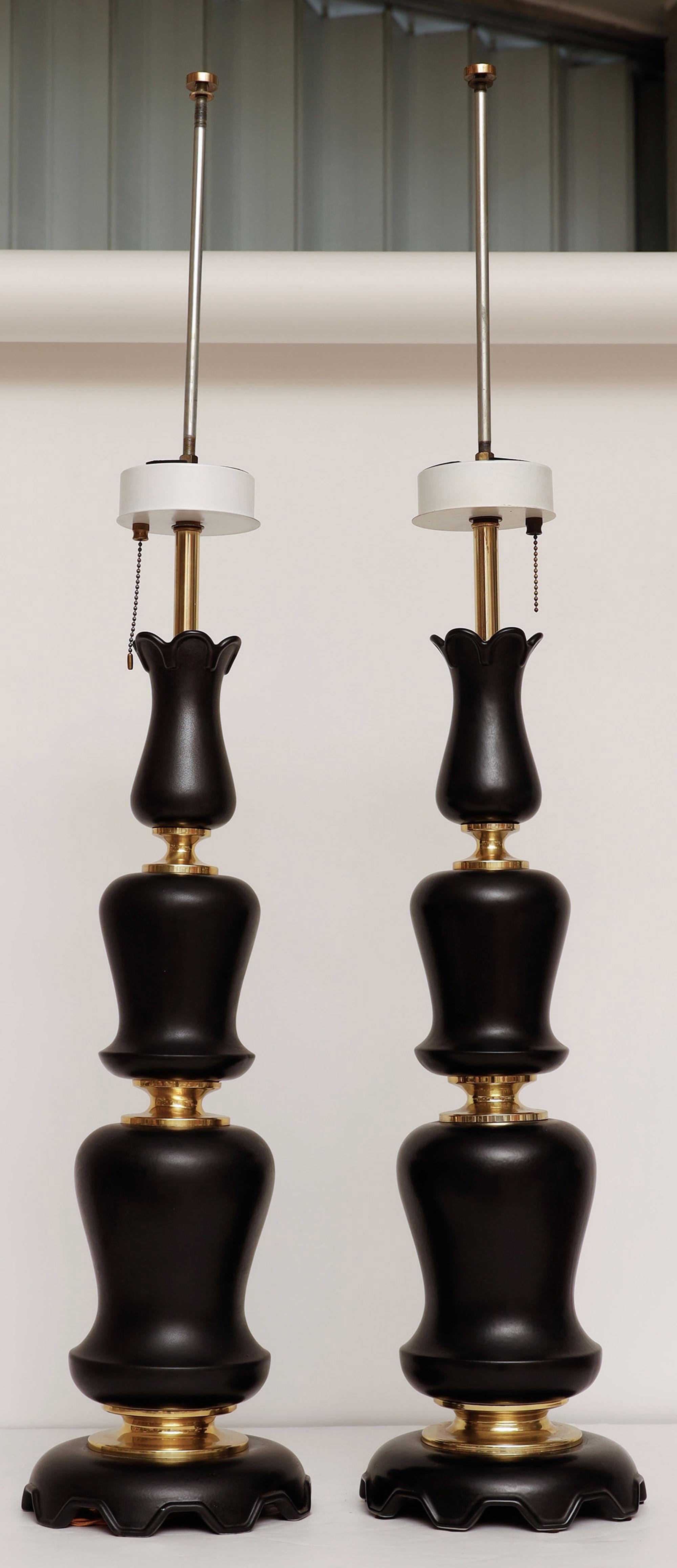 Pair of sculptural table lamps in black matte ceramic by Gerald Thurston for Lightolier.
The lamps each have three light sources and pull chain.

Very tall and elegant!