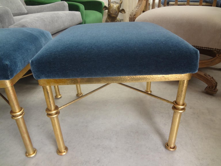 Pair of mid-century gilt iron ottomans. This beautiful pair of gilt ottomans, benches or stools with a knot design were taken down to the frame
and newly upholstered in steel blue mohair. Versatile pair!.