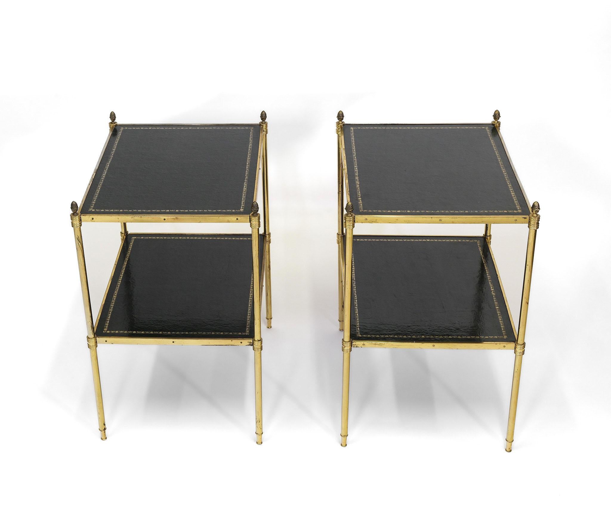 Un par de etageres de dos pisos de mediados de siglo de metal lacado dorado y cuero. Estilo Maison Baguès. Francés - Alrededor de 1950.

Mesas bien proporcionadas, con pisos de cuero negro con decoración dorada, sobre patas doradas lacadas con