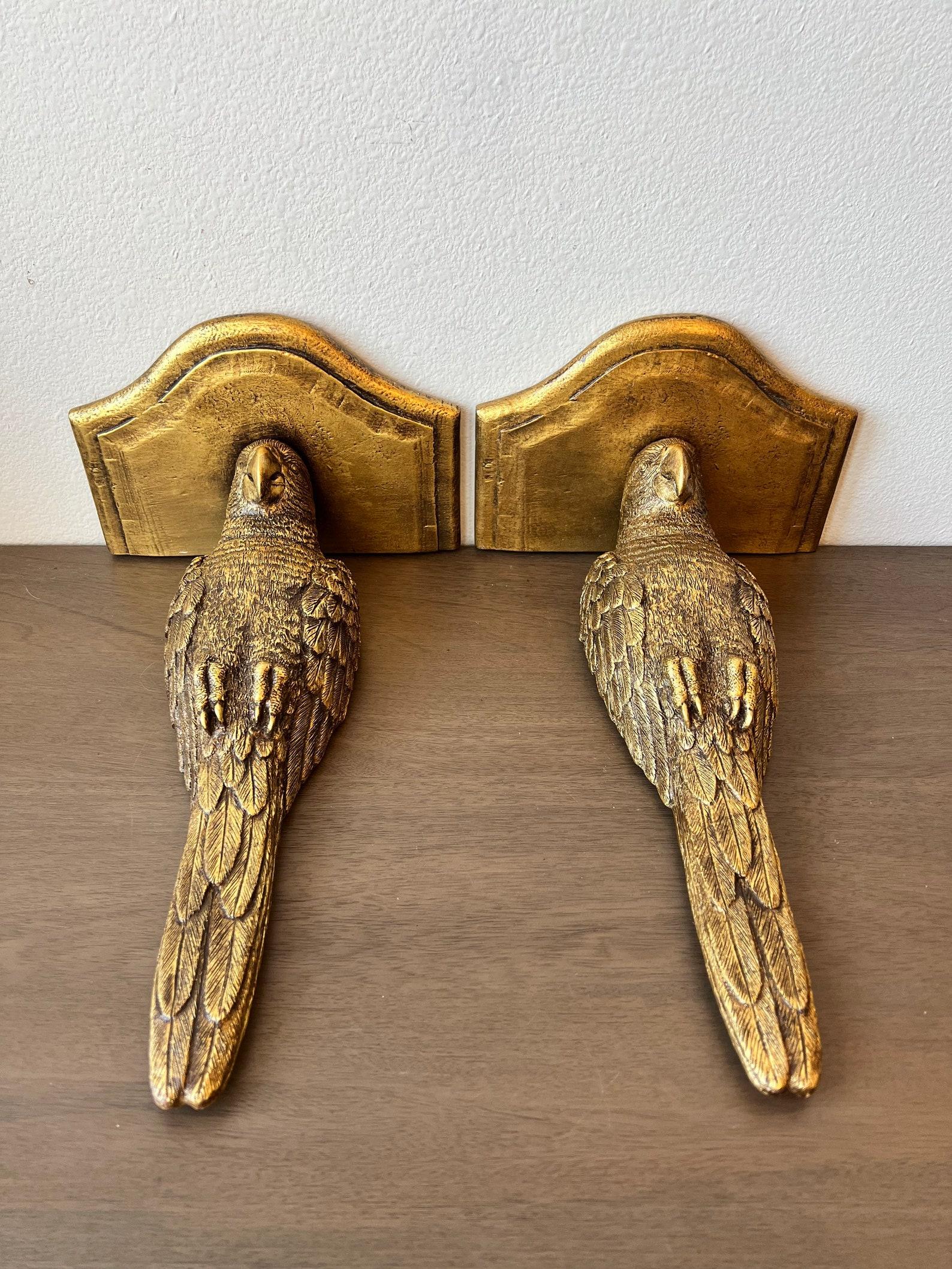 A most attractive pair of vintage sculptural avian wall brackets, mid-20th century, stunning Hollywood Regency Glam taste, finely detailed, rich brilliantly gilded finish composite parrot bird-form wall hanging bracket shelf.

Dimensions (approx,