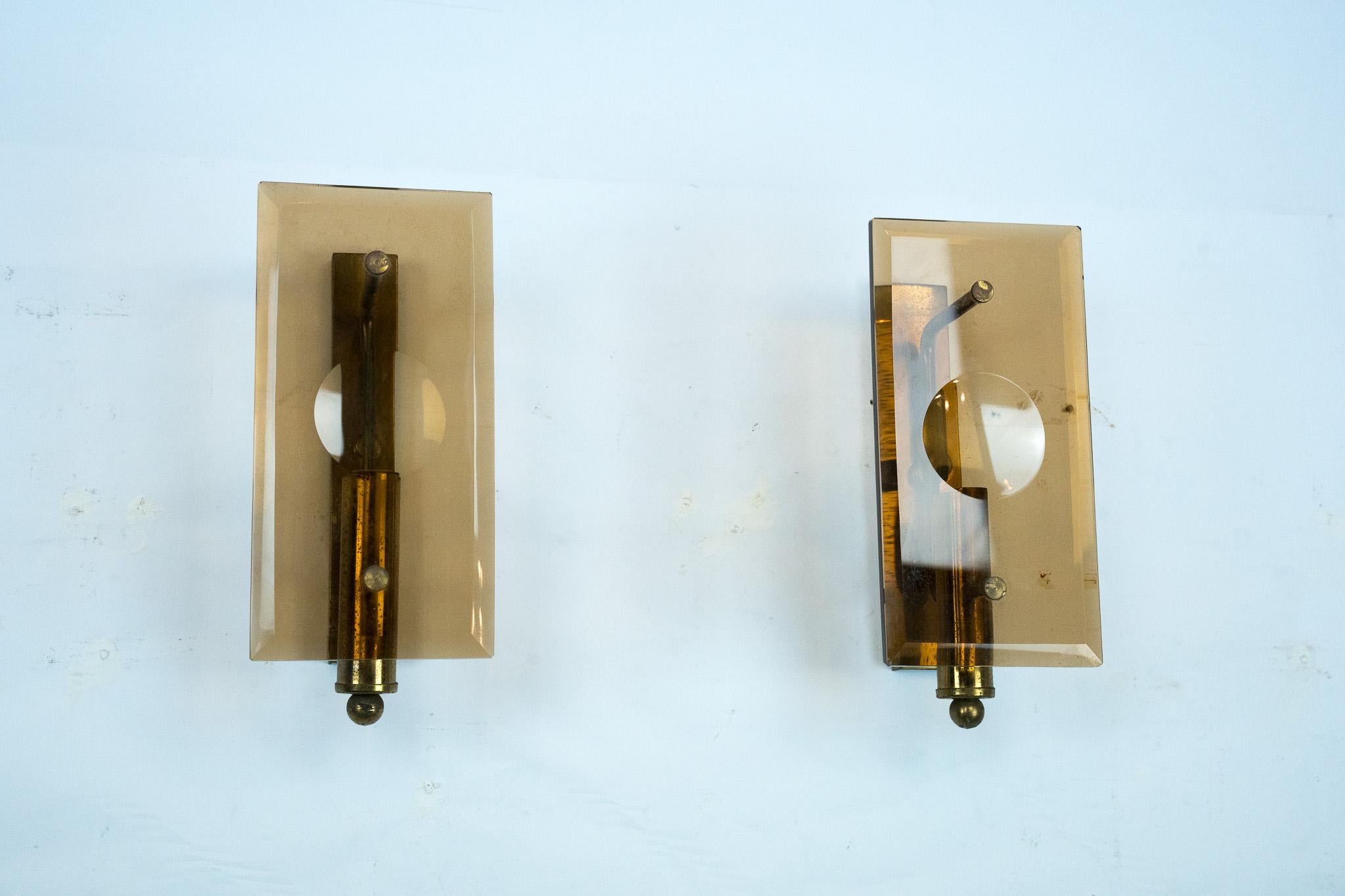 Ensemble de deux appliques rappelant le style de Cristal Art et produites en Italie dans les années 60. Elles sont fabriquées en verre ambré épais et en laiton et présentent une patine et des points d'origine. Les lunettes sont en parfait état.