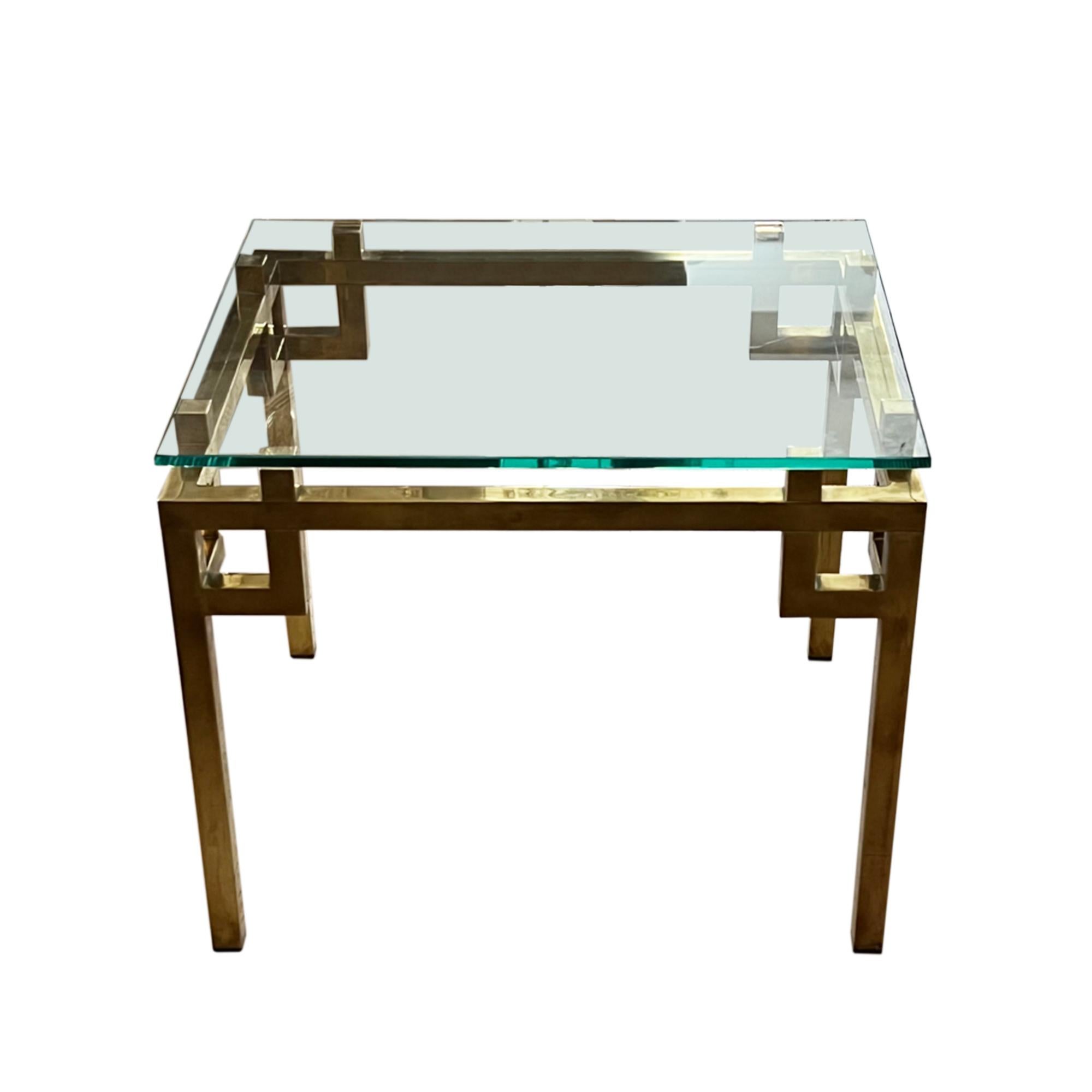 A very stylish pair of brass and glass mid century side tables.

With a geometric design to the base and a solid glass tops in the style of Guy Lefèvre.

Made in France in the 1960s - classic mid century design.