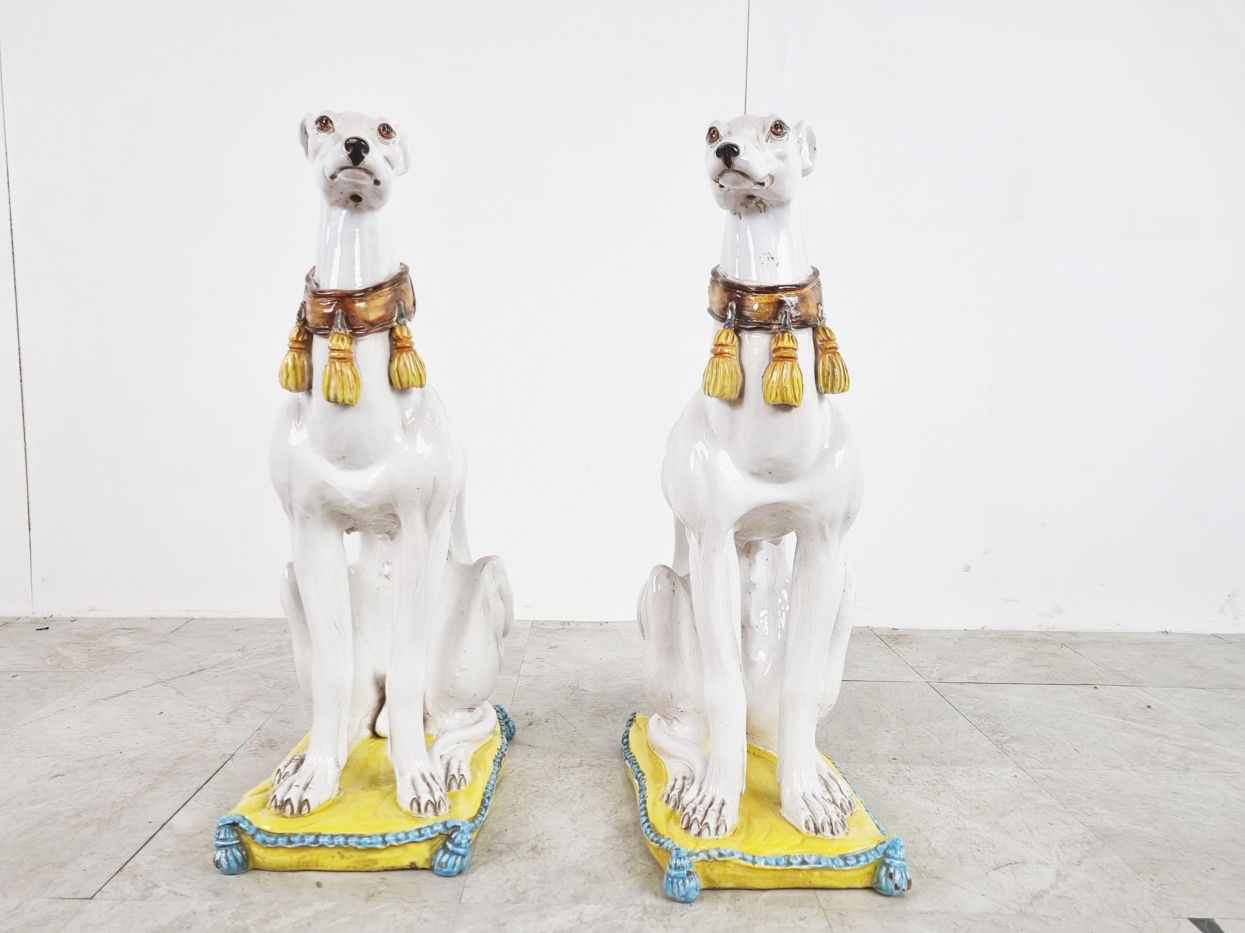 Pair of mid century glazed terracotta Grehyhound dog sculptures depicted sitting cushions.

Beautifully made with eye for details.

These life sized sculptures are very decorative, especially as a pair to decorate a entryway or living