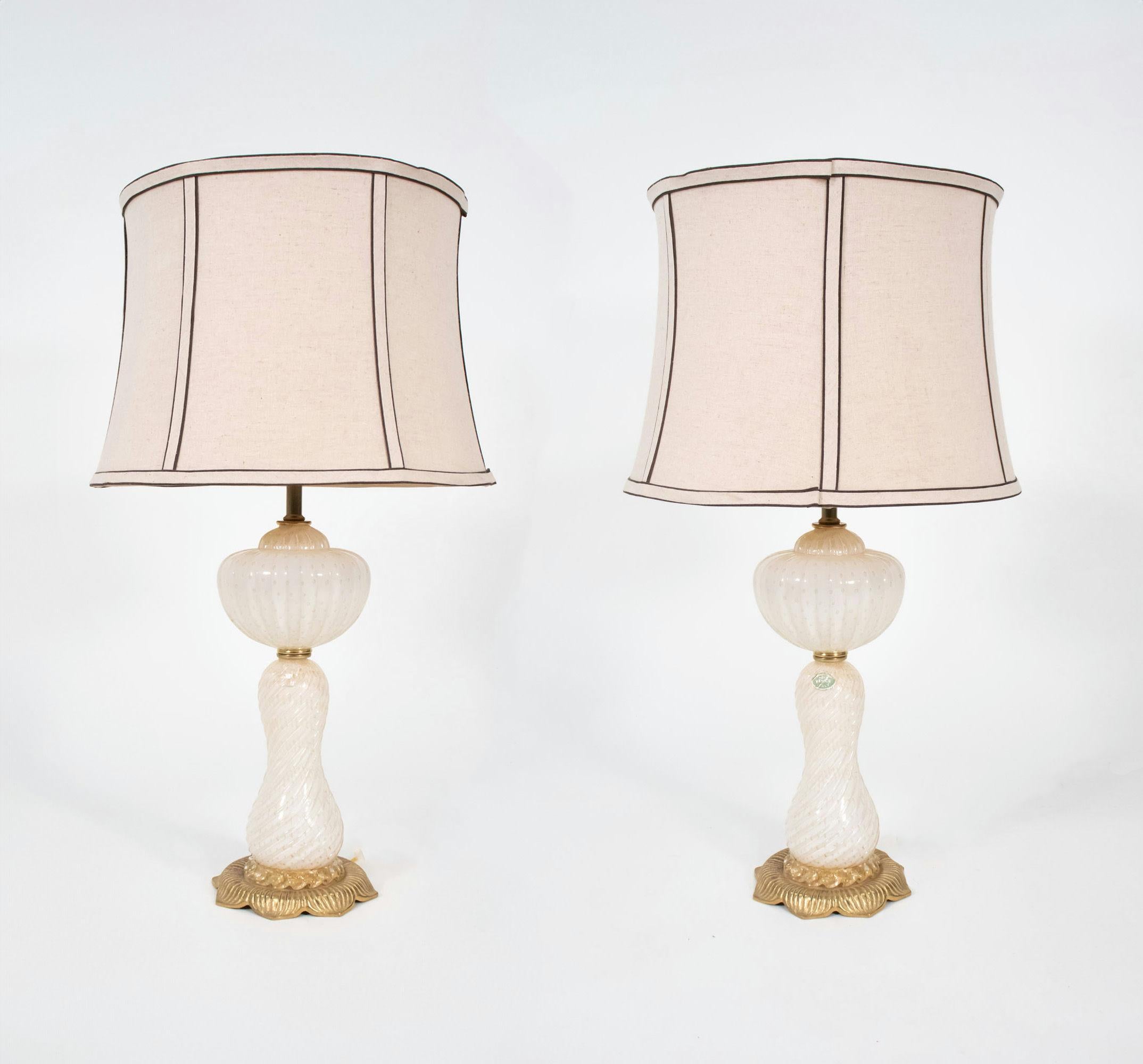 Questa coppia di lampade da tavolo di Murano di metà secolo, bianche e in avventurina, è stata realizzata nello stile di Barovier&Toso, una rinomata vetreria di Murano. Le lampade erano realizzate in vetro veneziano bianco impreziosito da macchie di