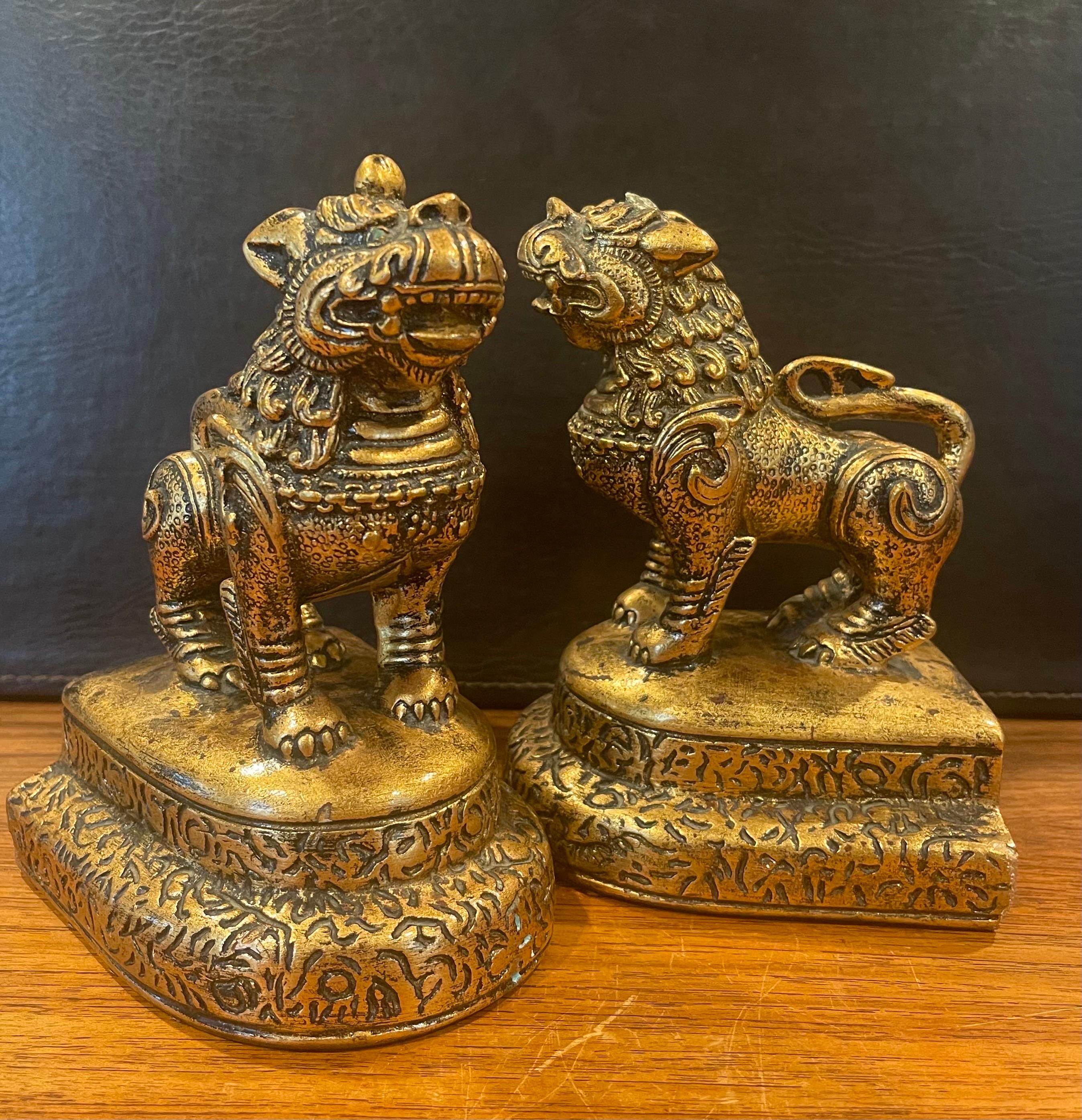 A very nice pair of mid-century gold gilt plaster foo dog bookends by Jaru of California, circa 1970s. These symbolic guardians present a beautiful hollywood regency vibe and are in very good vintage condition with the exception of a few small chips