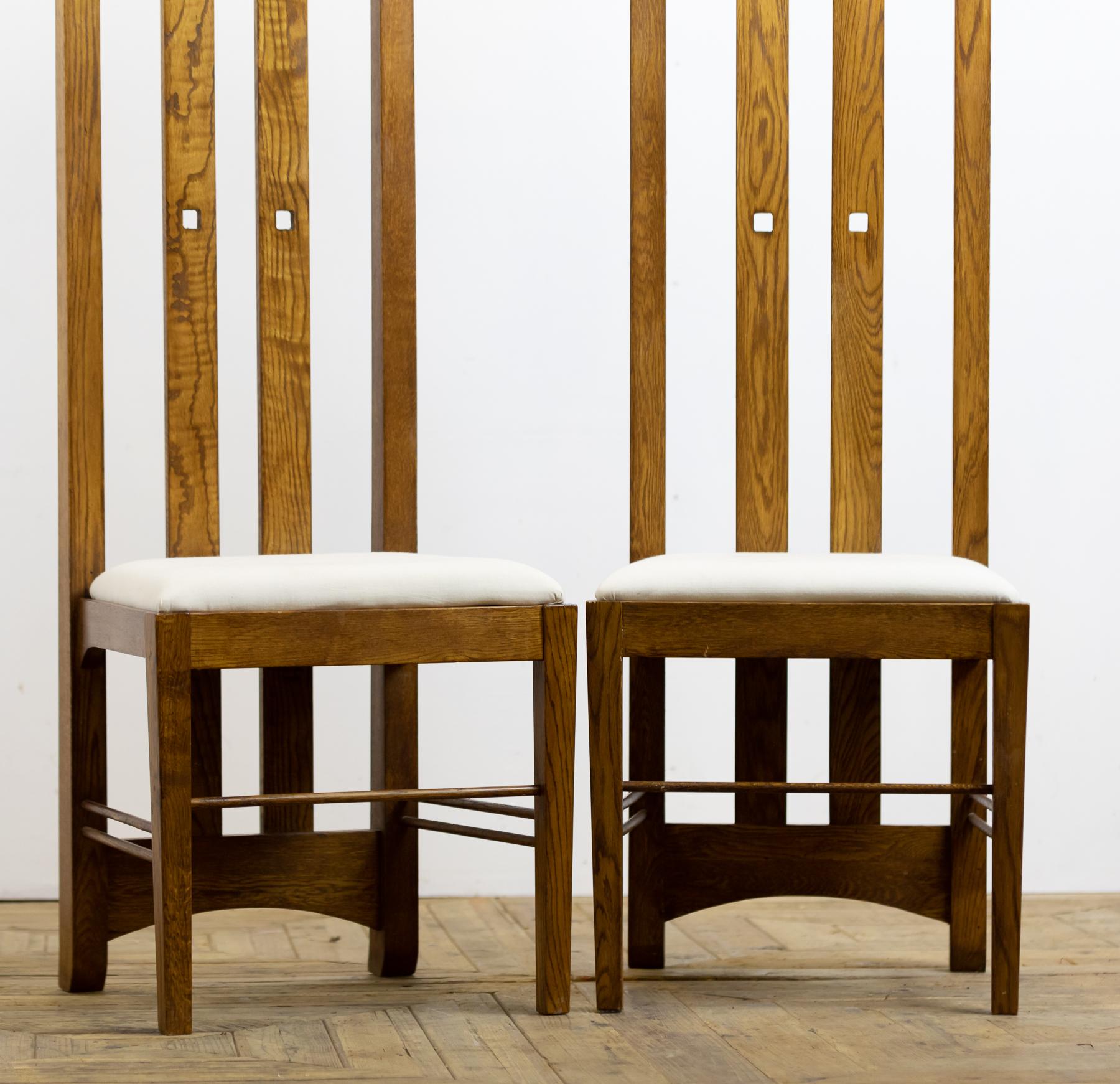 A wonderful pair of mid-20th century light oak chairs in the style of Charles Rennie Mackintosh. The original chairs were designed for Miss Cranston’s Ingram Street Tearooms. Upholstered with calico covered drop in seats.