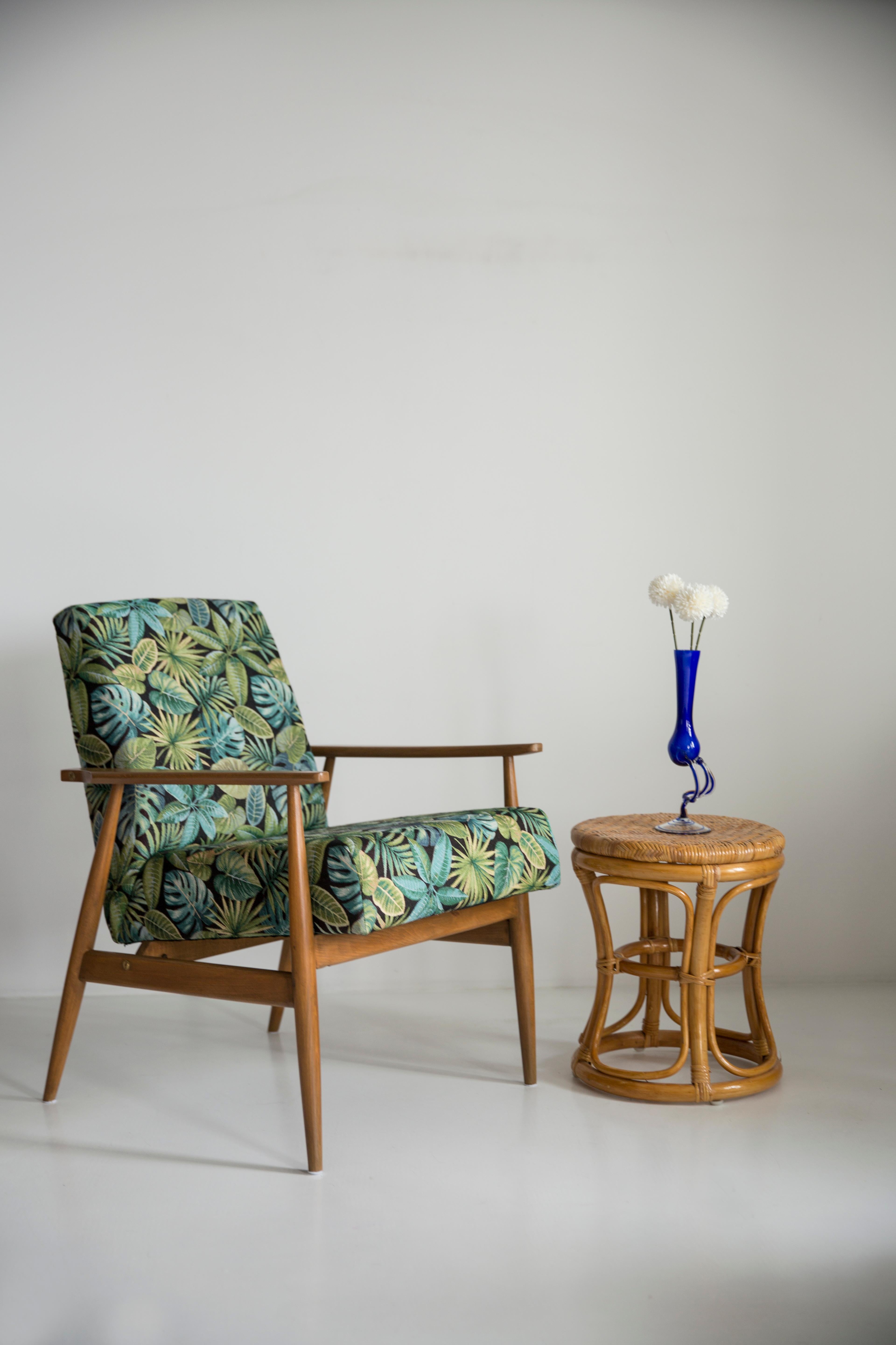 A beautiful, restored armchair designed by Henryk Lis. Furniture after full carpentry and upholstery renovation. The fabric, which is covered with a backrest and a seat, is a high-quality Italian Green Leaves Jacquard. The armchair will be perfect