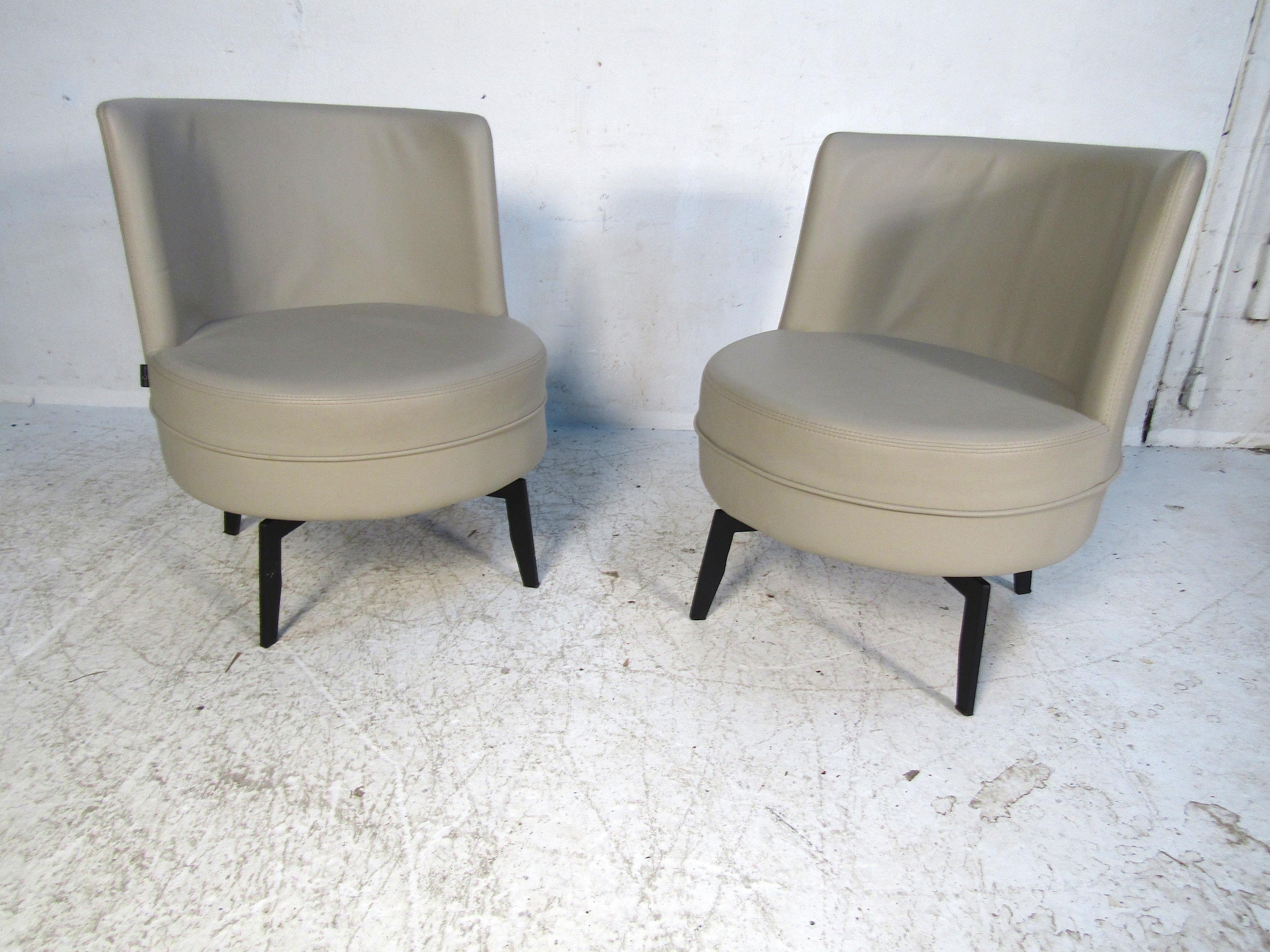 This pair of luxurious grey leather swivel chairs is sure to add a bold splash of design to any space. They feature sturdy metal legs with plush soft leather seats. They swivel a full 360 degrees making them perfect for any home library or sitting