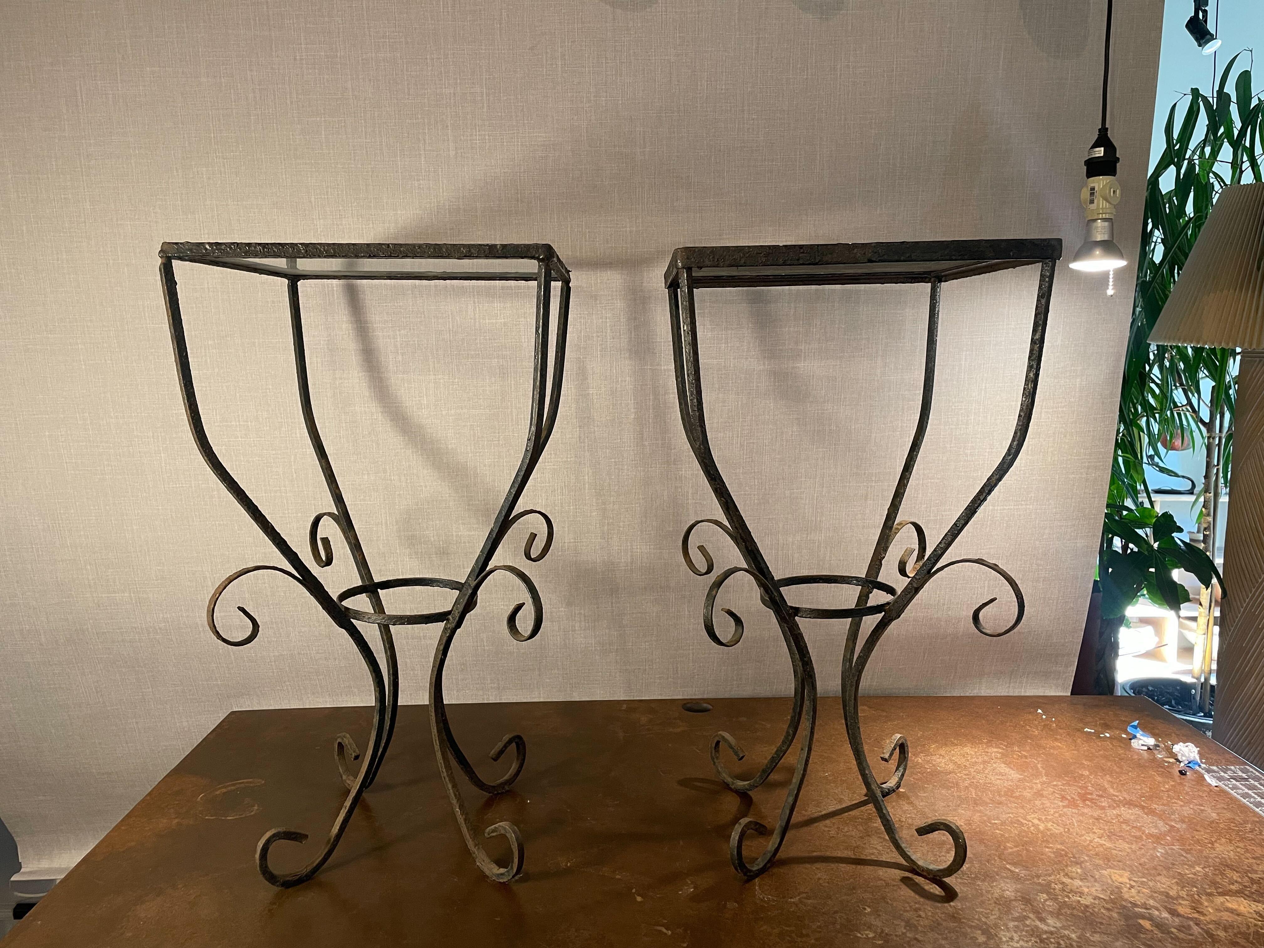 Une paire de tables d'appoint en fer forgé du milieu du siècle, à la fois raffinée et rustique, magnifiquement fabriquée avec des lignes gracieuses et un attrait intemporel. Chaque pièce est dotée d'une base en fer délicatement forgée à la main,