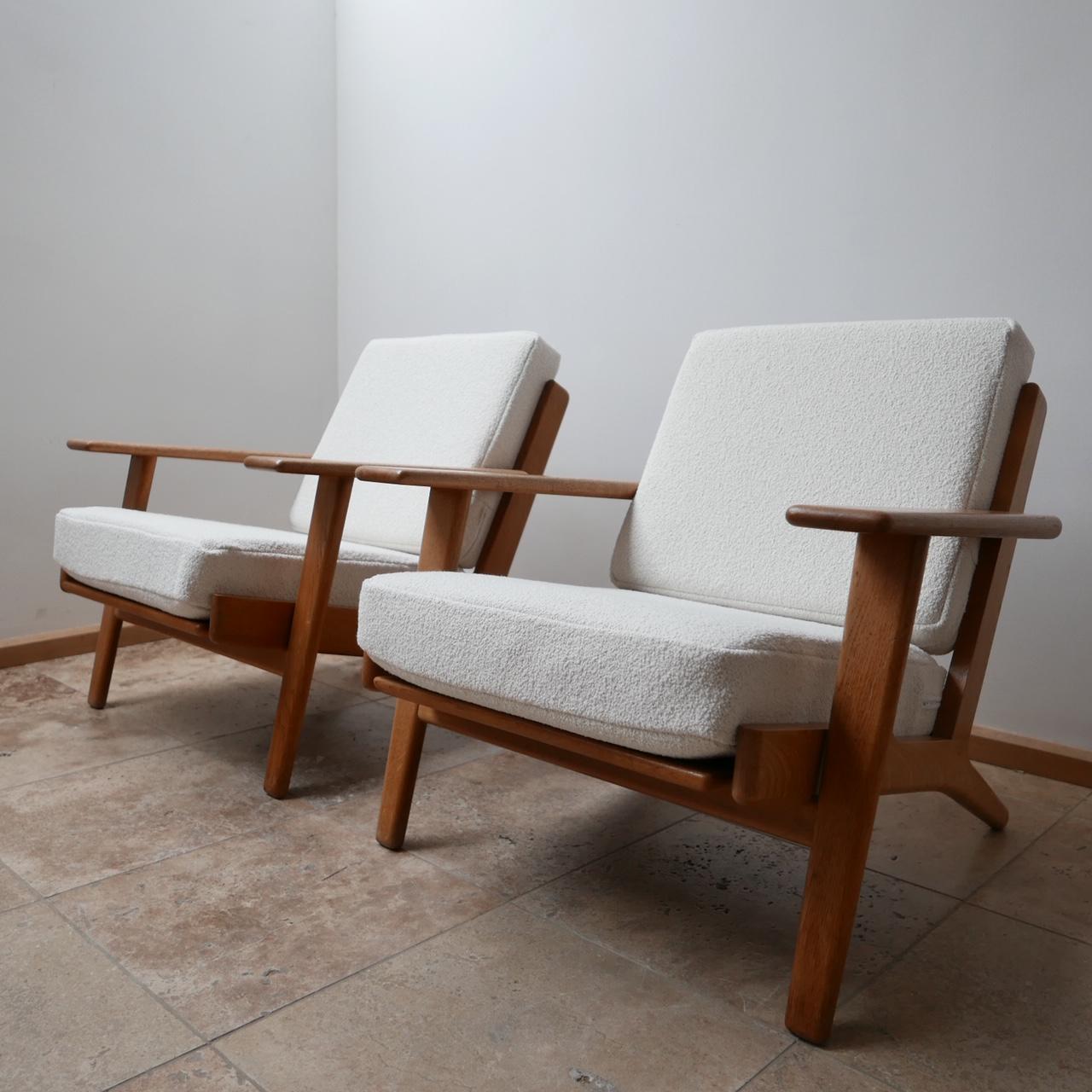 Original Hans Wegener midcentury armchairs.

A pair of the much desired GE-209 model.

Swedish, circa 1960s for GETAMA.

Timeless and legendary design.

Completely professionally re-upholstered in white bouclé from Chase